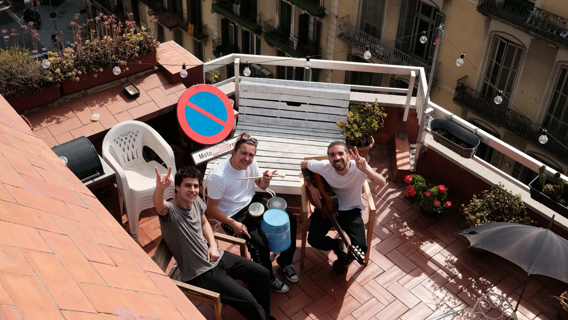 Stay Homas, a band of three roommate musicians in Barcelona, Spain, perform songs from their rooftop to get us through our COVID-19 "confinement blues." Three musician roommates sit on their rooftop and look up at the camera