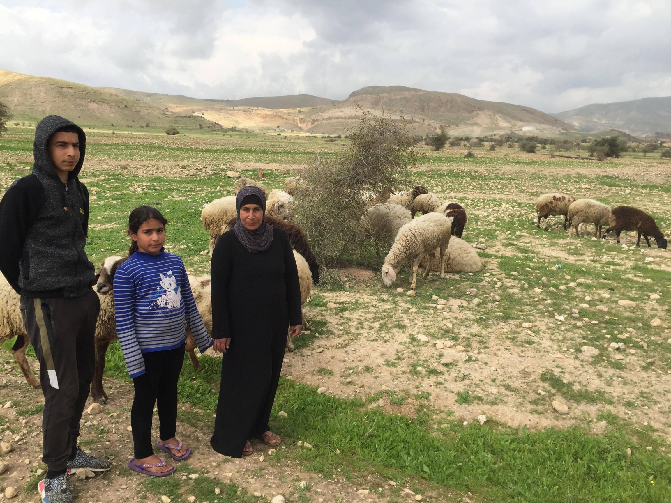 Iyad Ebbayat, left, his younger sister, and his mother, Noor Ebbayat with their sheep in the Palestinian village of Fasayil. Iyad Ebbayat, left, his younger sister, and his mother, Noor Ebbayat with their sheep in the Palestinian village of Fasayil.