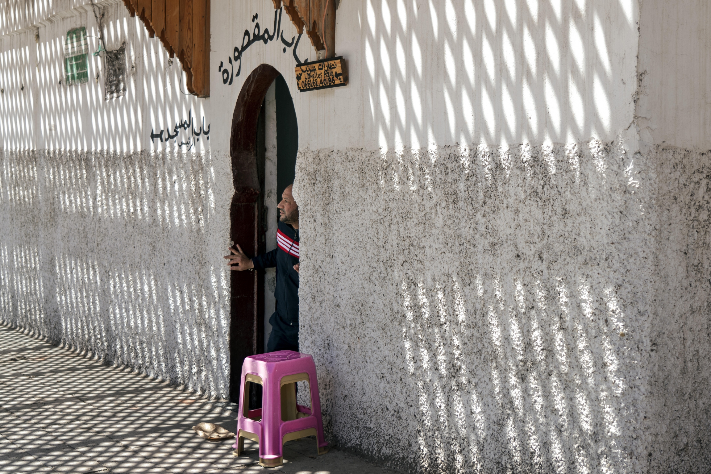 Imam Hamuda Nezhani peers out of the Souk Mosque in the Casablanca medina. The mosque is closed, but he comes daily to chant the call to prayer. Imam Hamuda Nezhani peers out of the Souk Mosque in the Casablanca medina. The mosque is closed, but he comes daily to chant the call to prayer.