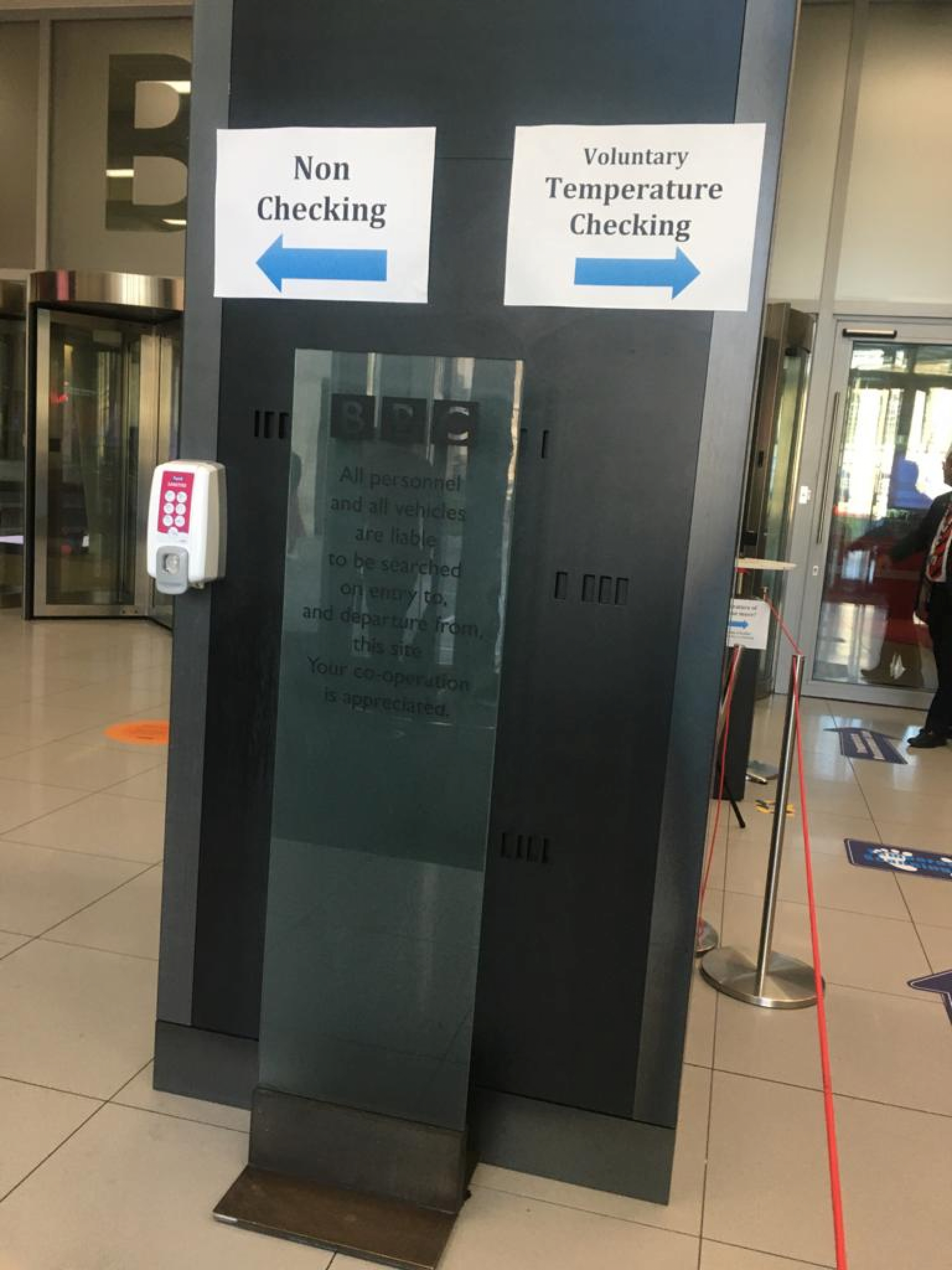 Signs in the BBC lobby in London guiding staff and visitors to voluntary temperature checks. Signs in the BBC lobby in London guiding staff and visitors to voluntary temperature checks.