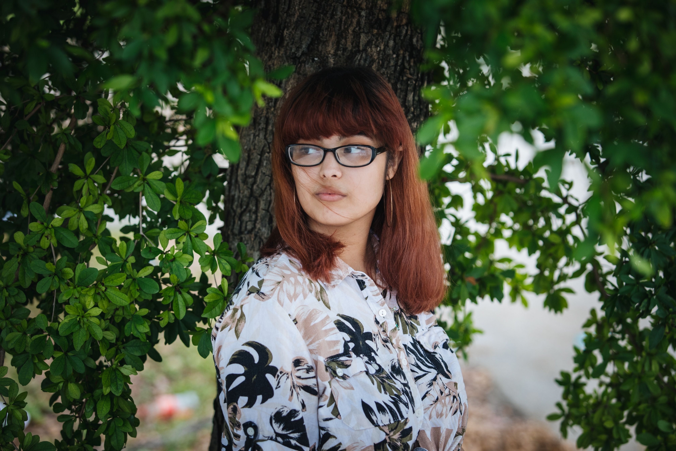 For "Pink" Ayuso, one of the 3.1 million eligible Latino voters in Florida, the pandemic has underscored how difficult it is for immigrants in Miami — and across the country — to access health care. A young woman on a floral shirt posses for a photo in a garden.