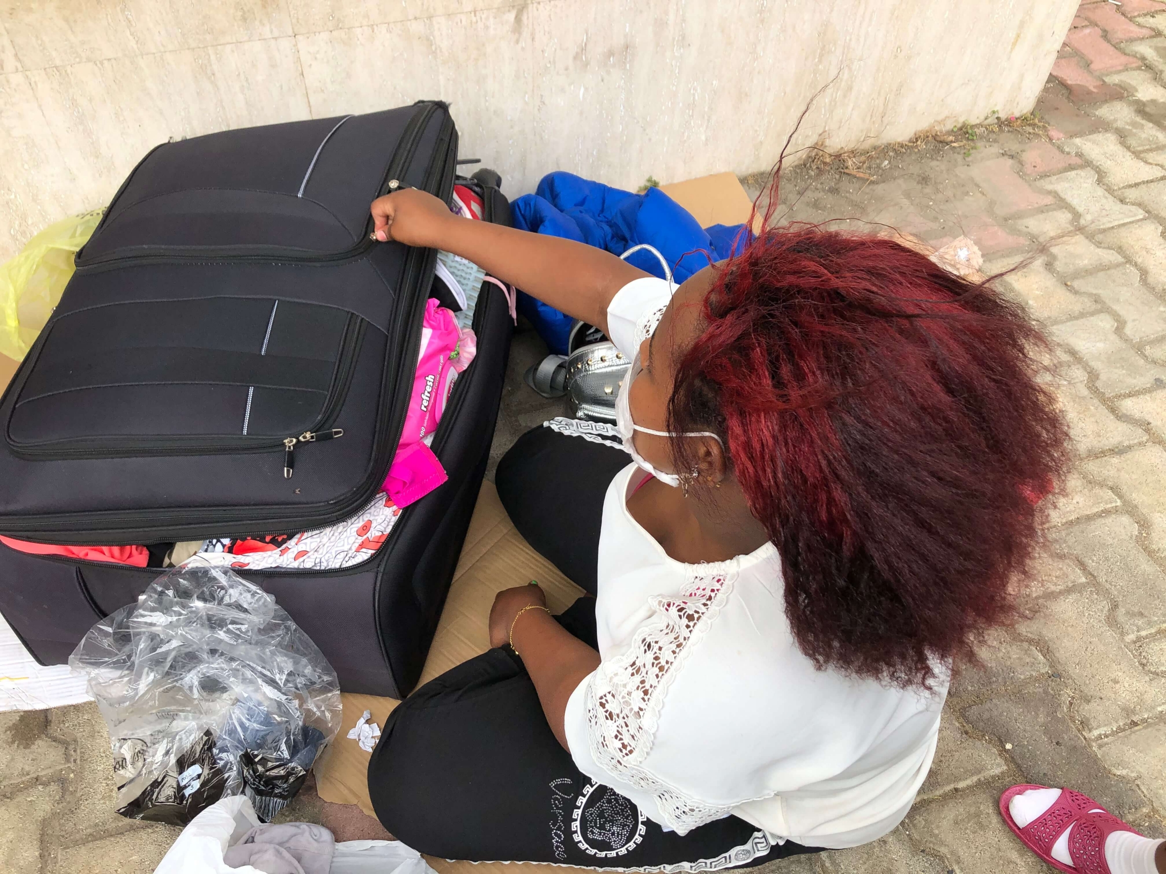 An Ethiopian woman looks through her bags outside the Ethiopian Embassy in Beirut, Lebanon. An Ethiopian woman looks her black suitcase