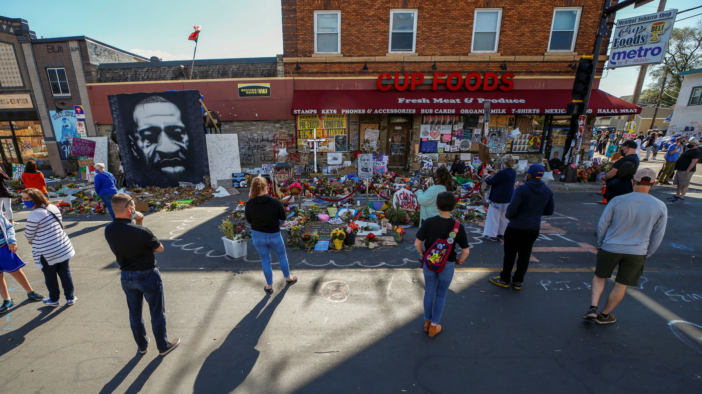 Visitors look at a memorial at the site of the arrest of George Floyd, who died while in police custody, in Minneapolis, June 14, 2020. Visitors look at a memorial at the site of the arrest of George Floyd, who died while in police custody, in Minneapolis, June 14, 2020.