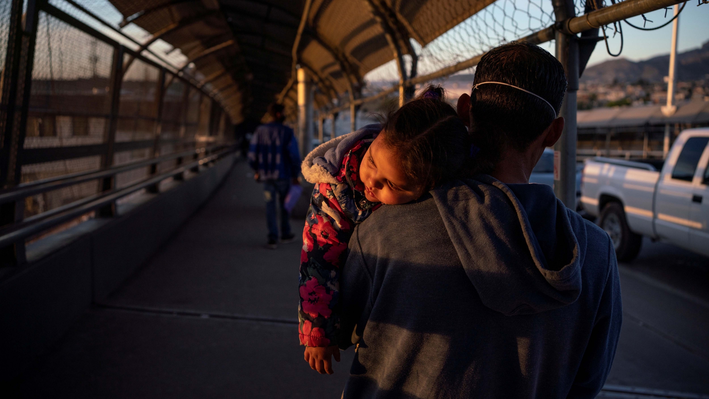 A migrant father and child cross the Paso del Norte International Bridge after court cancelations amid the coronavirus disease (COVID-19) outbreak in Ciudad Juárez , Mexico, April 20, 2020. A migrant father and child returns to Ciudad Juárez after he had his family's court dates changed by Customs and Border Protection on the Paso del Norte International Bridge after court cancelations amid the coronavirus disease (COVID-19) outbreak in Ciud
