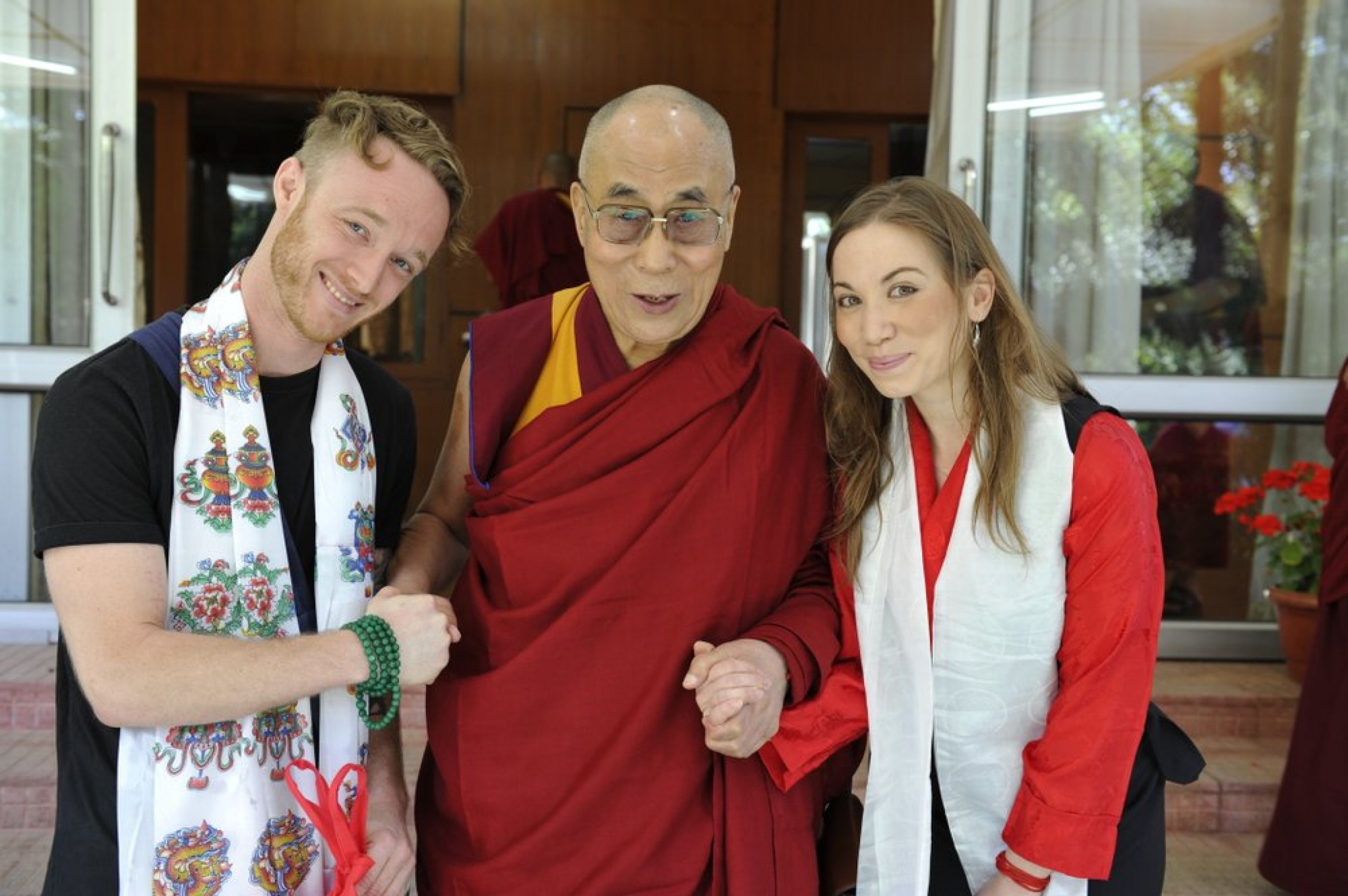 Dalai Lama, center, is pictured with Abe Kunin, left, and Junelle Kunin. The Tibetan spiritual leader released his first album, "Inner World" featuring teachings and mantras set to music. The Dalai Lama posses for a photo with a man and a woman. They are holding hands.
