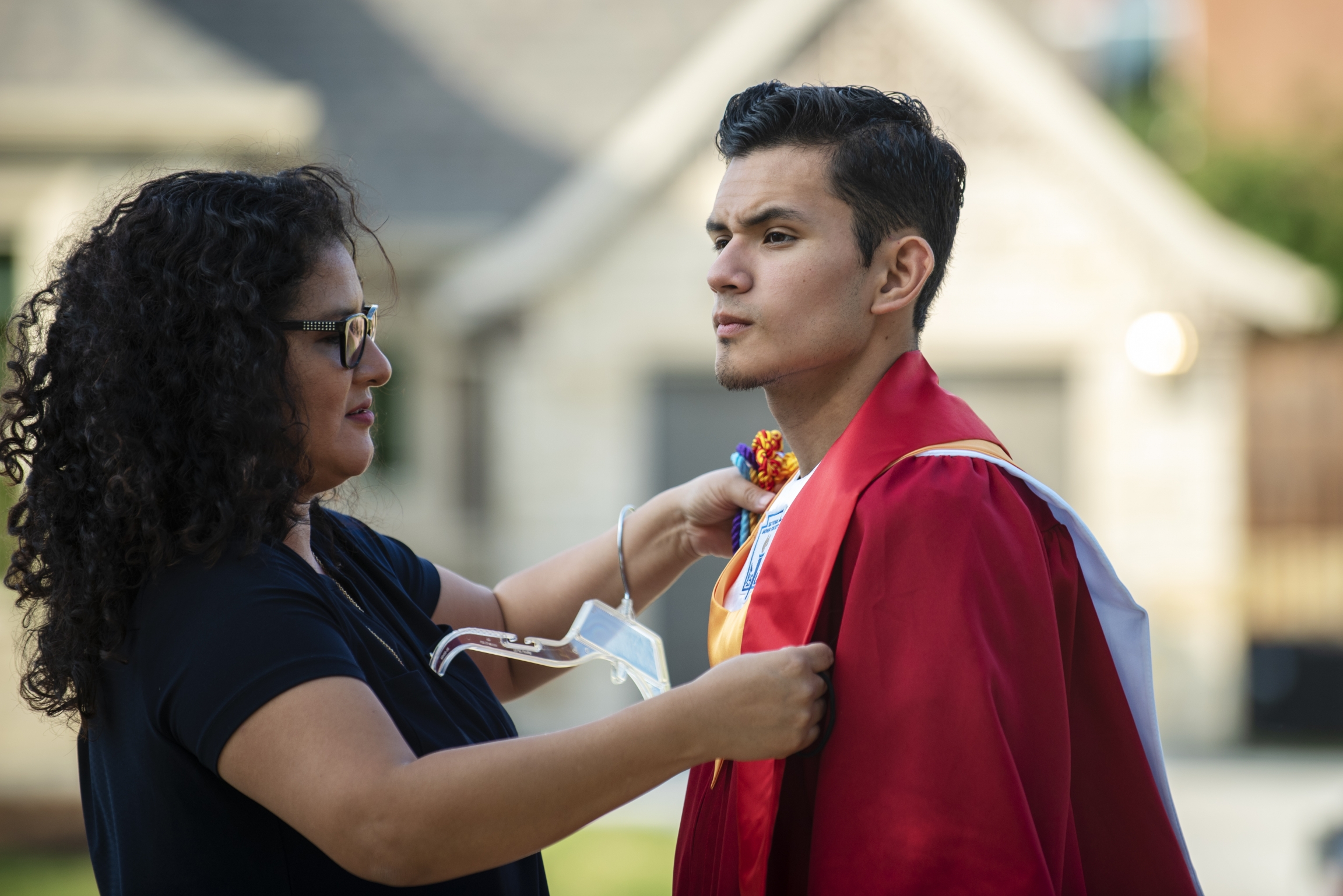 Xochitl Ortiz, left, helps her son Izcan Ordaz to try on his graduation gown outside their home in Keller, Texas, May 28, 2020. Xochitl Ortiz, left, helps her son Izcan Ordaz to try on his graduation gown outside their home in Keller, Texas, May 28, 2020.