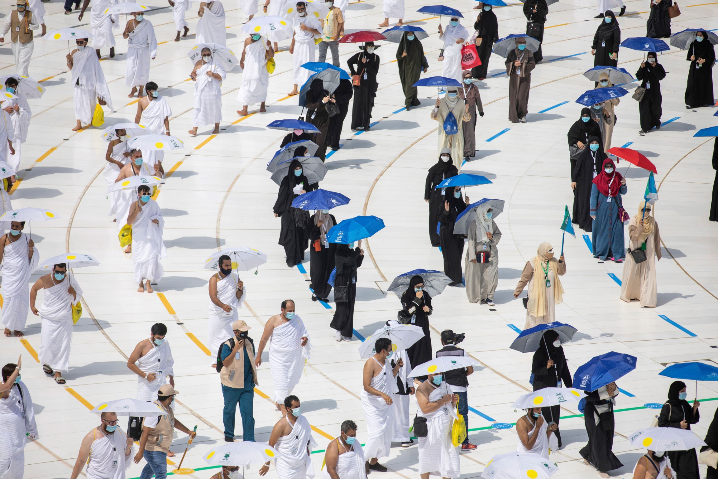 Pilgrim attend the hajj at the Grand Mosque. Pilgrims are shown walking on designated lines circuling the Kaaba.