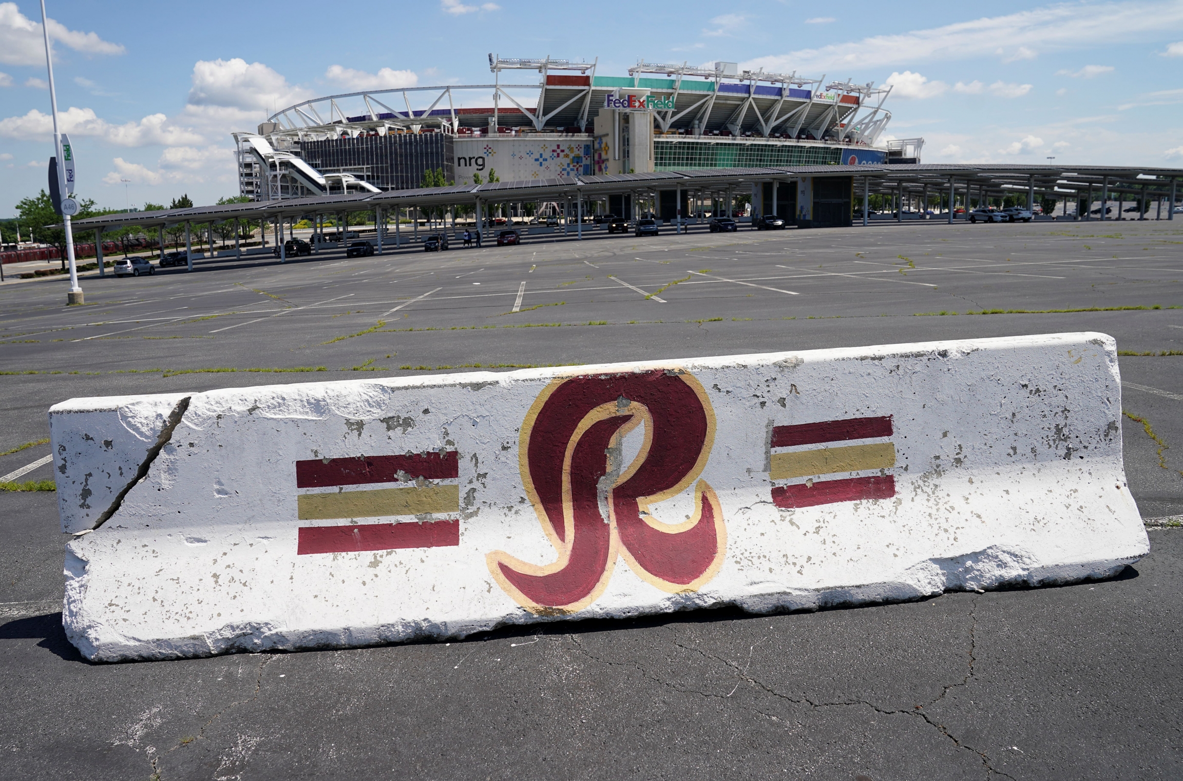 A Washington NFL team-themed barricade is seen in the parking lot outside FedEx Field after the team announced it will abandon its controversial team name and logo that contains a racial slur, Landover, Maryland, July 13, 2020. A parking barricade features the red letter R in a parking lot outside of a stadium.