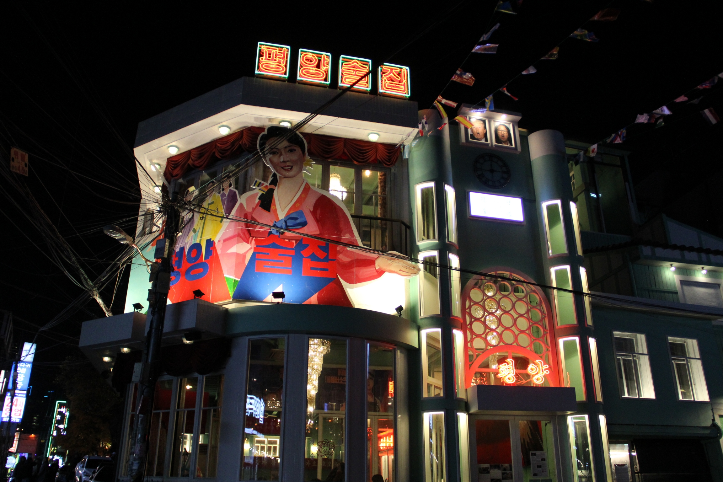 The outside of Pyongyang Pub features a drawing of a smiling North Korean woman. Jolly North Korean tunes blast from the speakers at the entrance The outside of Pyongyang Pub features a drawing of a smiling North Korean woman. Jolly North Korean tunes blast from the speakers at the entrance