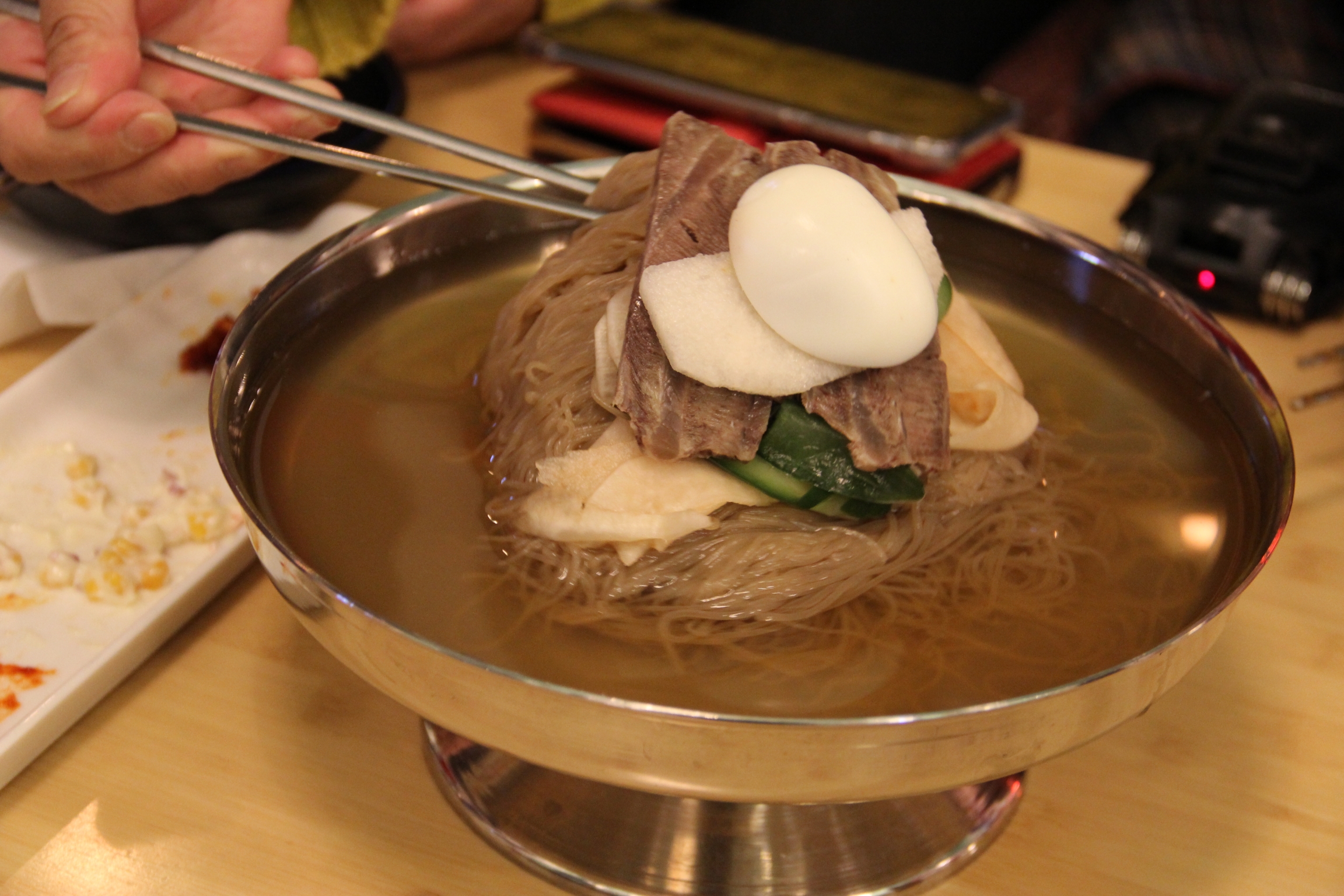 Kim Eun-joo was surprised that the mool naengmyun (cold noodles) were served in a wide-rimmed brass goblet, just like in North Korea. Kim Eun-joo was surprised that the mool naengmyun (cold noodles) were served in a wide-rimmed brass goblet, just like in North Korea.