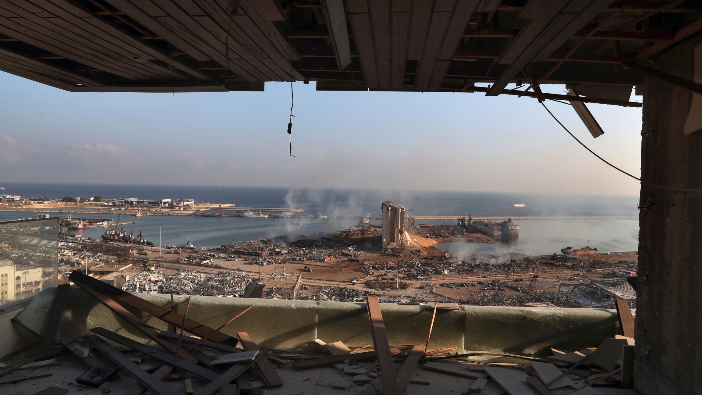 A view of the site of an explosion in the port of Beirut, Lebanon, Wednesday, Aug. 5, 2020. A view of the site of an explosion in the port of Beirut with buildings turned to rubble and shown from inside a facility with it's window blown out.