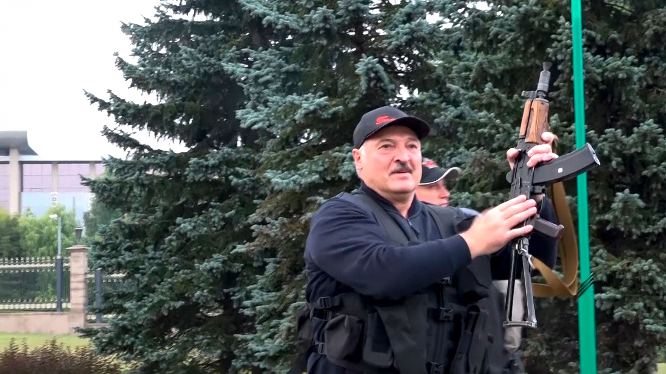 This image made from video provided by the State TV and Radio Company of Belarus, shows Belarus President Alexander Lukashenko armed with a Kalashnikov-type rifle near the Palace of Independence in Minsk, Belarus, Aug. 23, 2020. Alexander Lukashenko is shown wearing a hat and black vest while holding an assault rifle in the air.