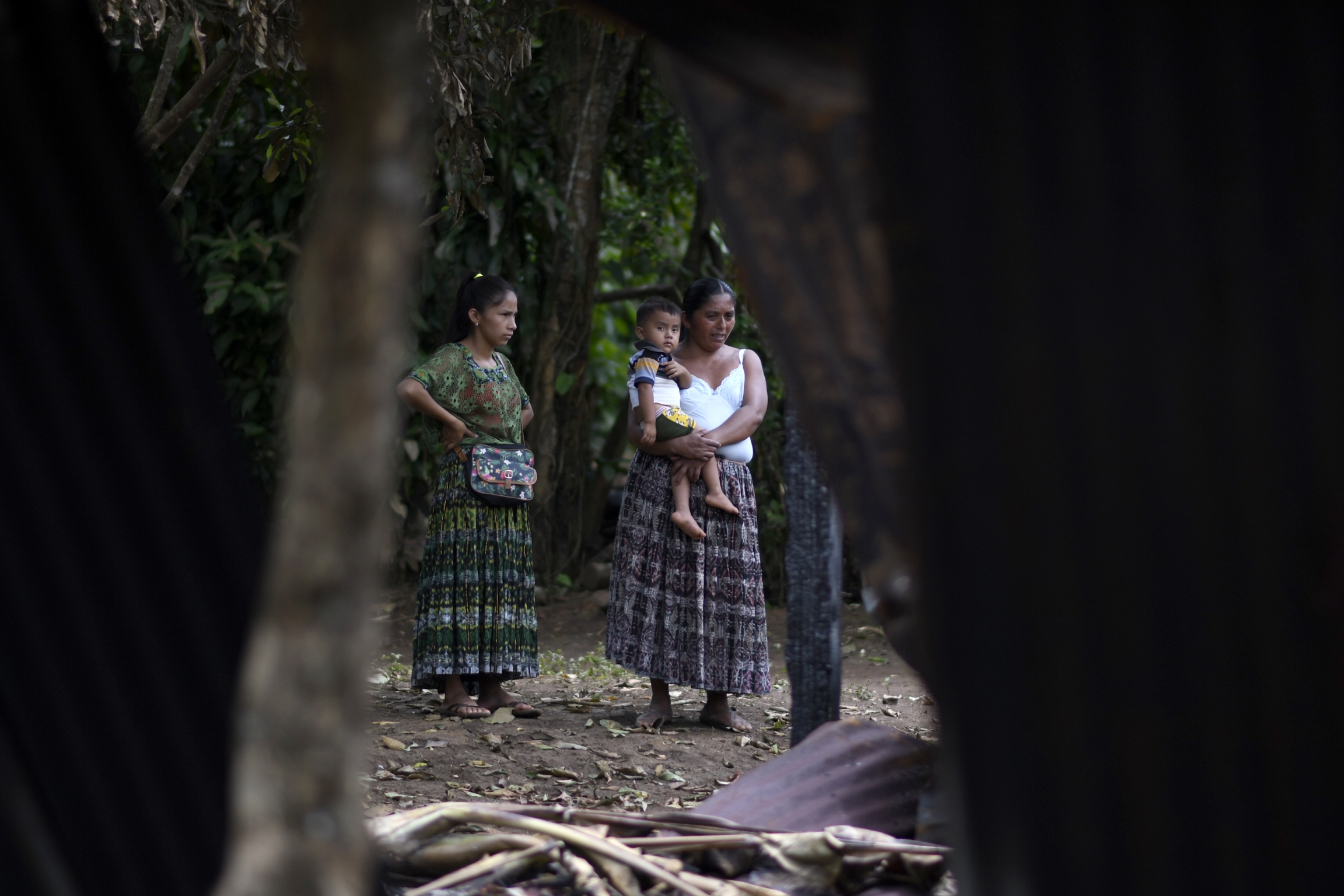 Gendered violence in Guatemala disproportionately affects Indigenous women. A standing woman holds a baby on her hip next to another woman.