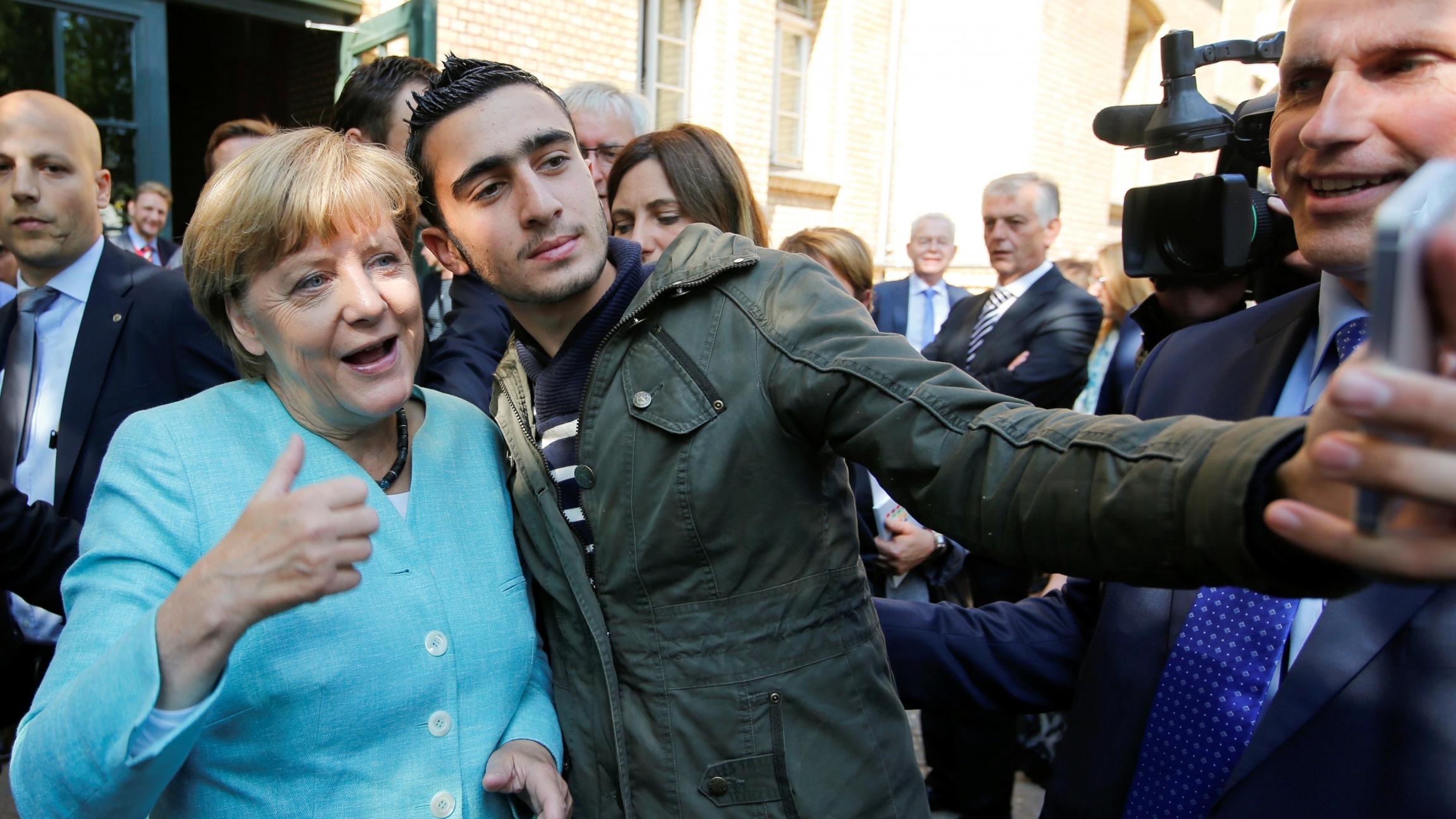 Syrian refugee Anas Modamani takes a selfie with German Chancellor Angela Merkel outside a refugee camp near the Federal Office for Migration and Refugees after registration at Berlin's Spandau district, Germany, on September 10, 2015. Syrian refugee Anas Modamani takes a selfie with German Chancellor Angela Merkel outside a refugee camp near the Federal Office for Migration and Refugees after registration at Berlin's Spandau district, Germany, on September 10, 2015.