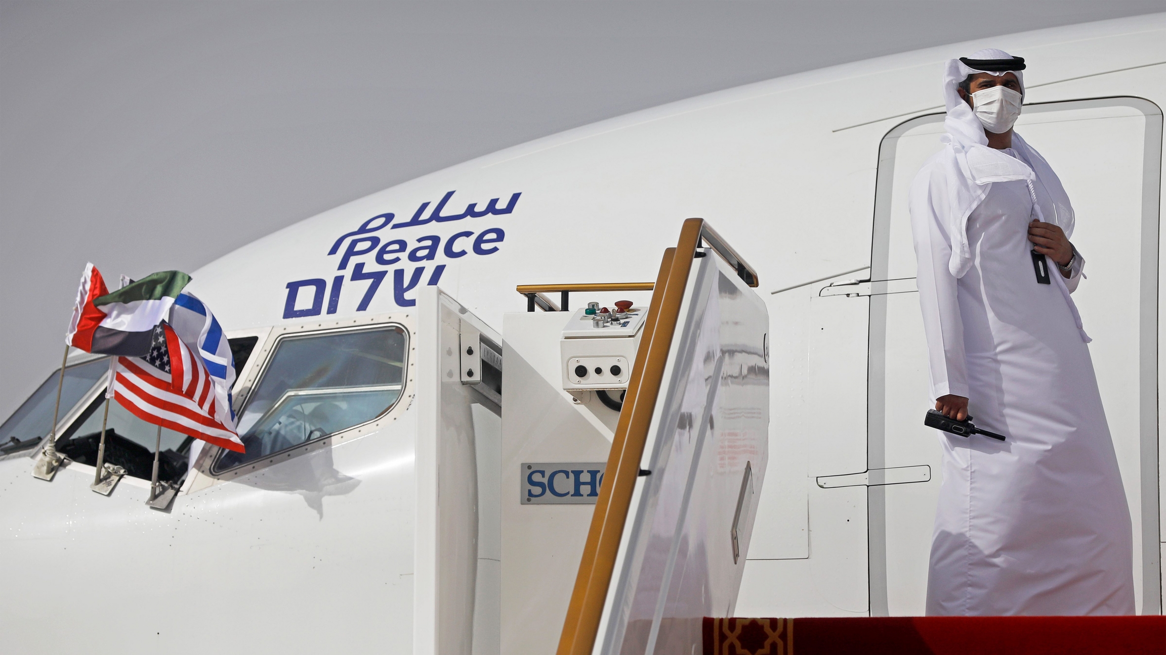 An official stands at the door of an Israeli El Al airliner after it landed in Abu Dhabi, United Arab Emirates, on Monday, Aug. 31, 2020. A man dressed in white stands by the closed door of an airplane.