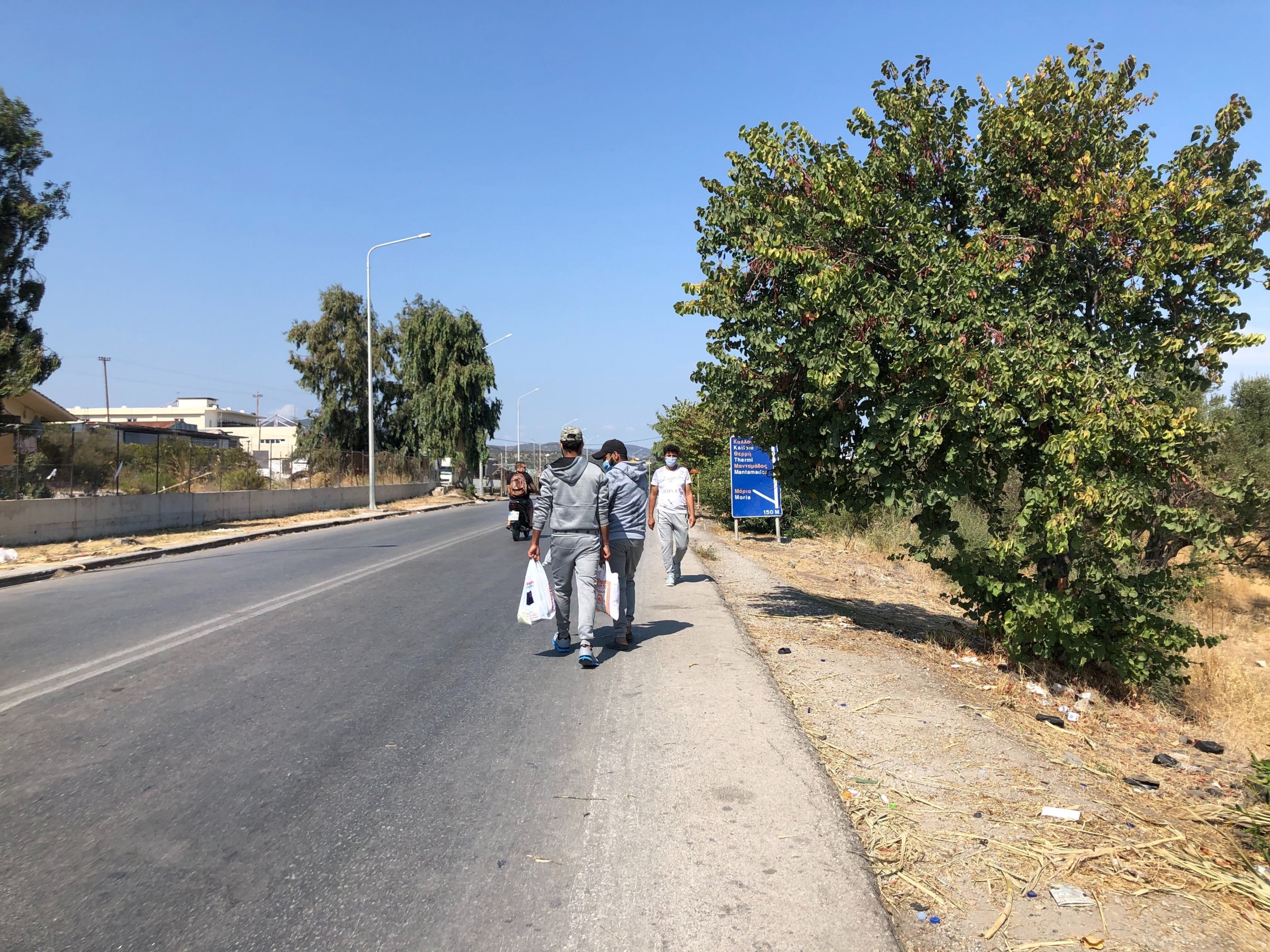 Two Syrian asylum-seekers return from a shopping trip to the port city of Mytilene, where they picked up rice, tomato sauce and other food. They say the food being distributed at the camp is not enough. Two Syrian asylum-seekers return from a shopping trip to the port city of Mytilene, where they picked up rice, tomato sauce and other food. They say the food being distributed at the camp is not enough.