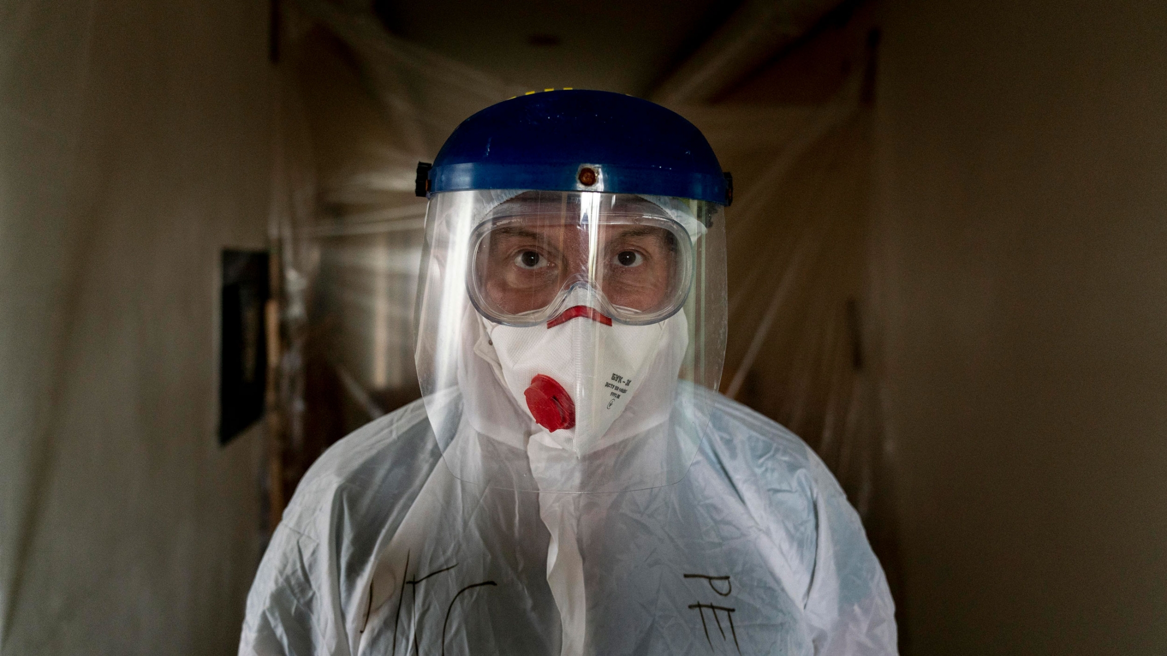 Dr. Oleh Hornostayev walks through a corridor at the hospital in Stryi, Ukraine, Sept. 29, 2020. A doctor is shown looking directly into the camera and wearing goggles, a face mask and a face shield.