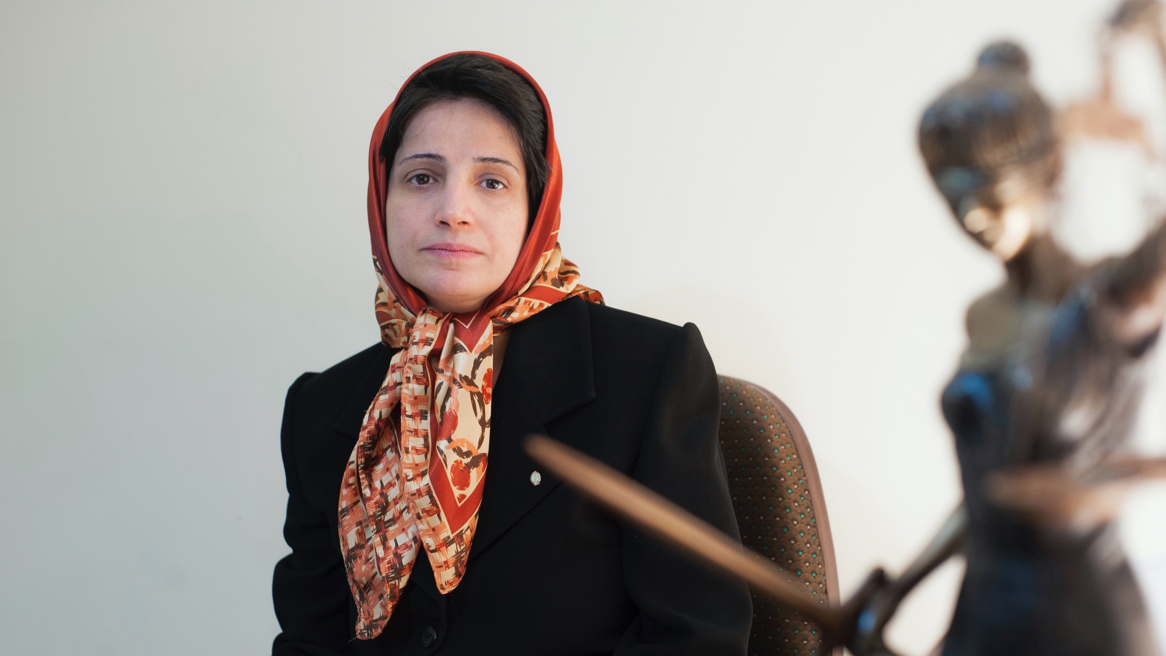 In this Nov. 1, 2008, file photo, Iranian human rights lawyer Nasrin Sotoudeh poses for a photograph in her office in Tehran, Iran. A woman wearing a head scarf sits at her desk and poses for a photograph.