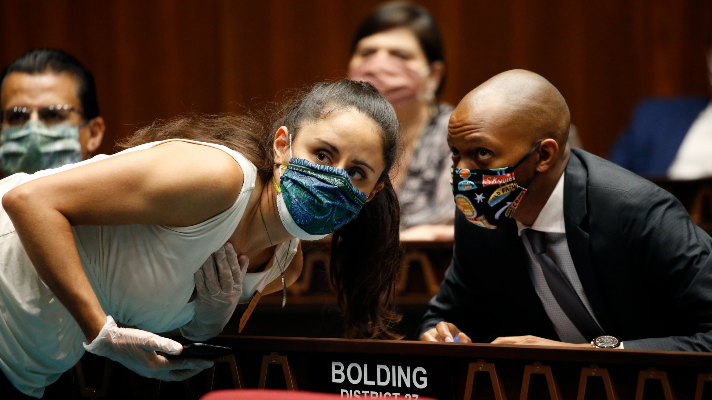 Rep. Athena Salman, left, talks with Rep. Reginald Bolding during a vote in the Arizona House of Representatives to end the 2020 session due to the coronavirus, May 19, 2020, in Phoenix.