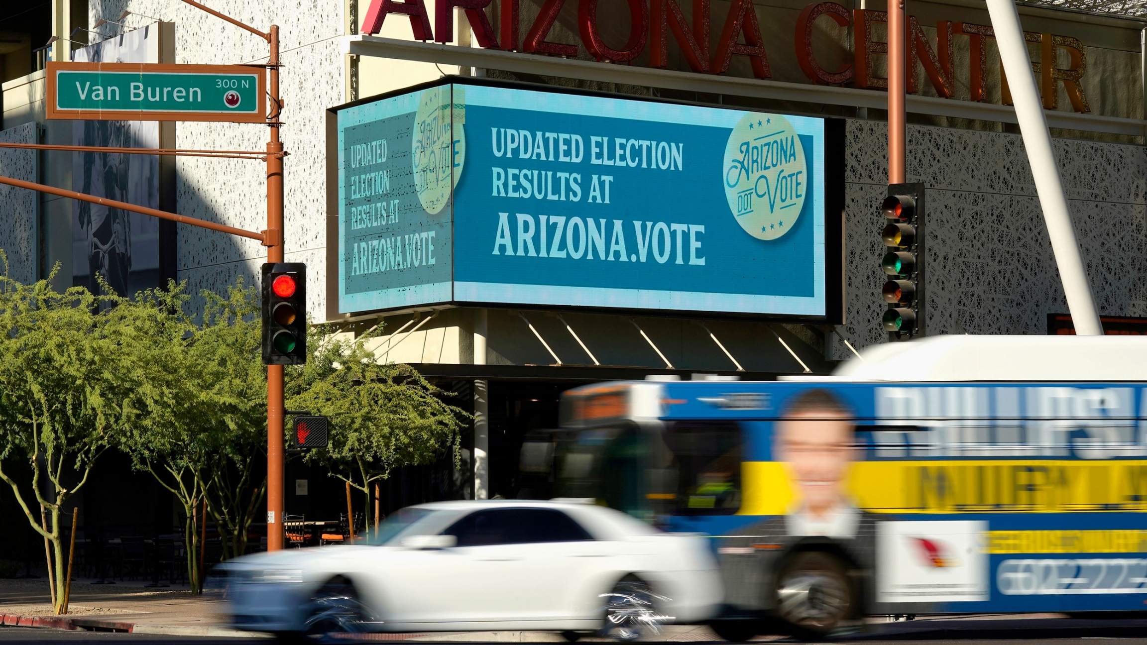 As votes are still counted in Arizona a billboard posts a site where people can look for election results, in Phoenix, Arizona, Nov. 4, 2020. An electonic billboard is shown with information about the Arizona vote as vehicles pass by.