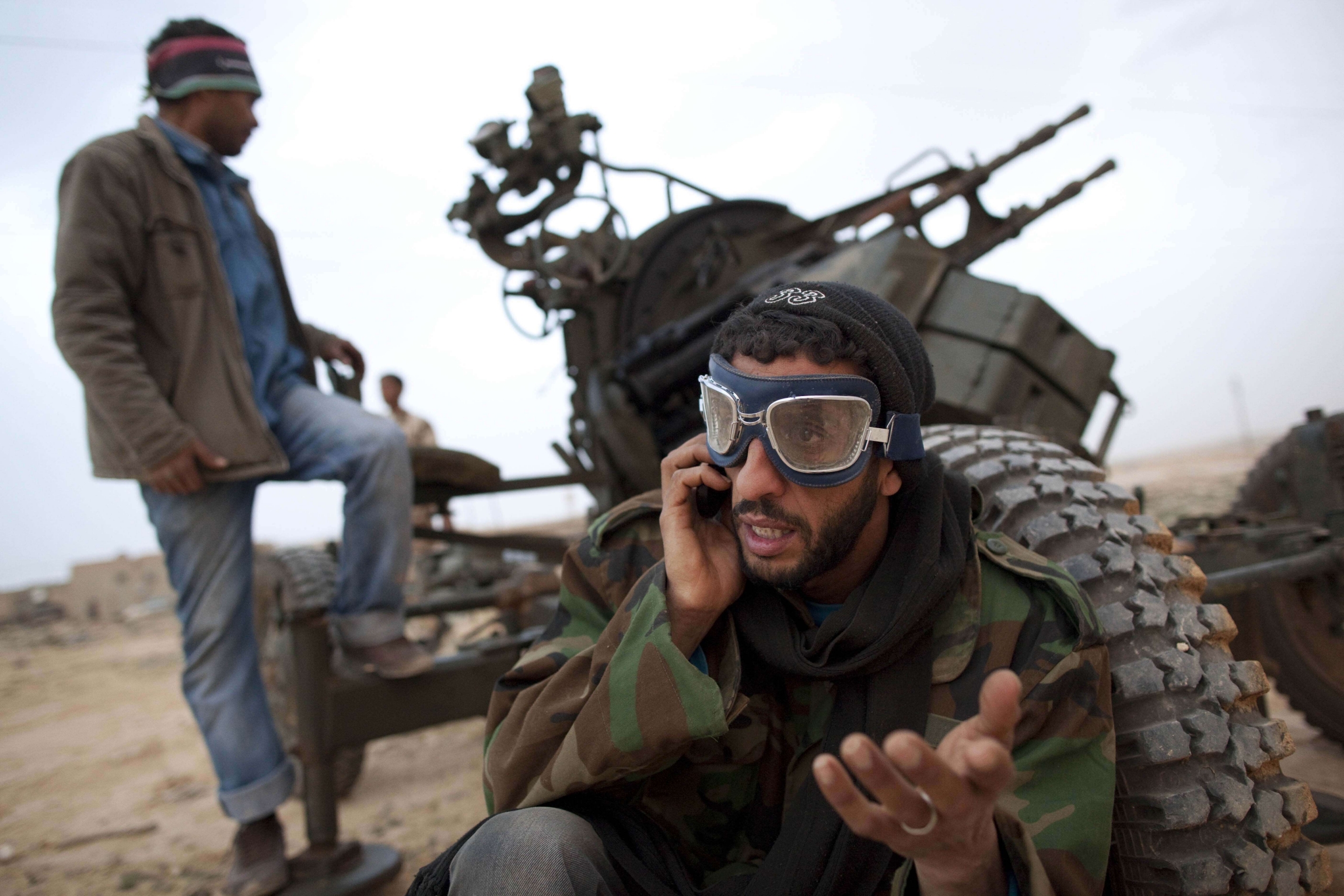 In this March 4, 2011 file photo, Libyan rebels who are part of the forces against Libyan leader Moammar Gadhafi stand with an anti-aircraft gun as they prepare to fight on the front-line near Ras Lanuf, west of the town of Brega, eastern Libya.