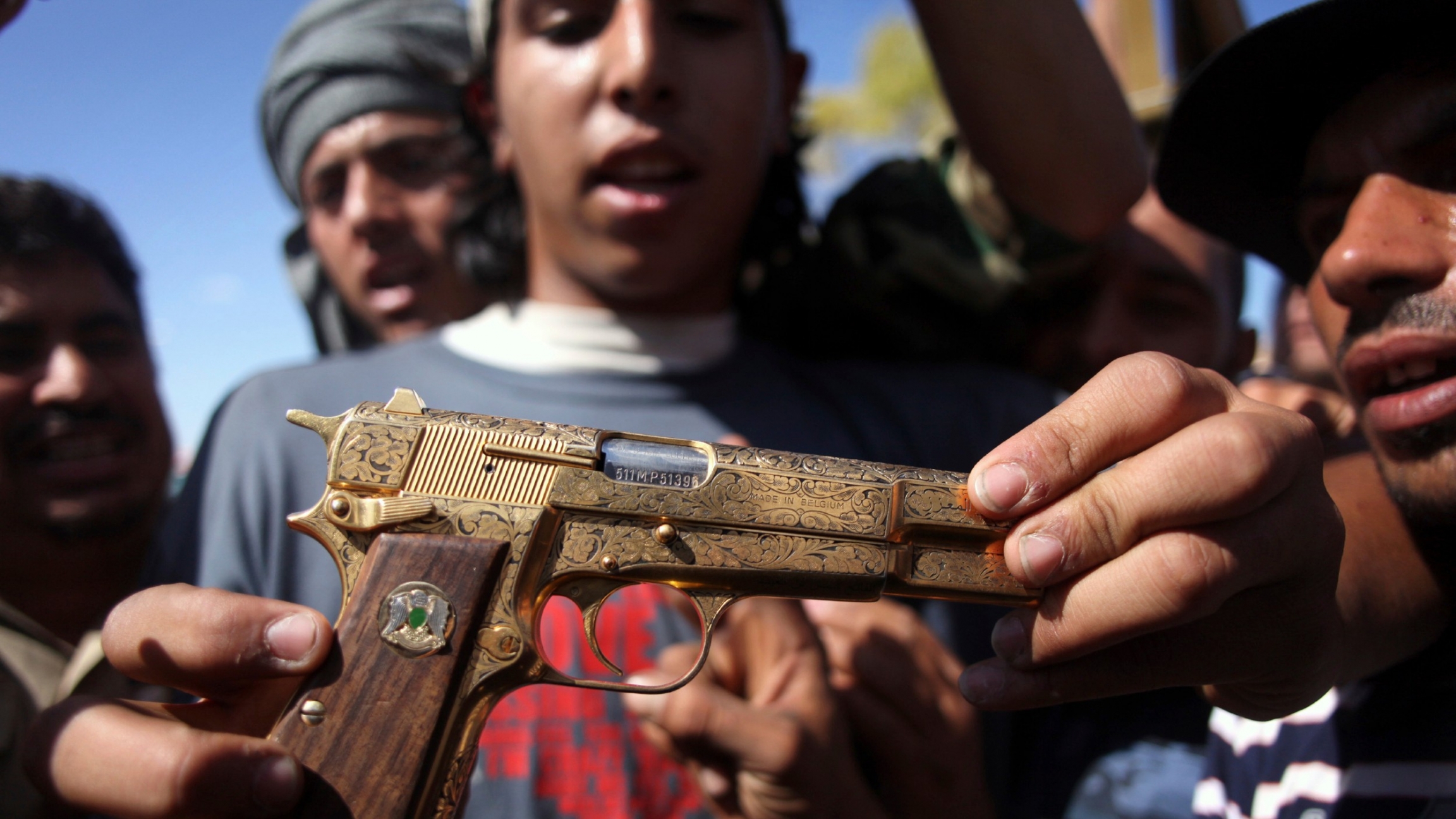 In this Oct. 20, 2011, file photo, Mohammed al-Babi holds a golden pistol he says belonged to Muammar Gadhafi in Sirte, Libya. Mohammed al-Babi holds a golden pistol he says belonged to Muammar Gadhafi in Sirte, Libya.