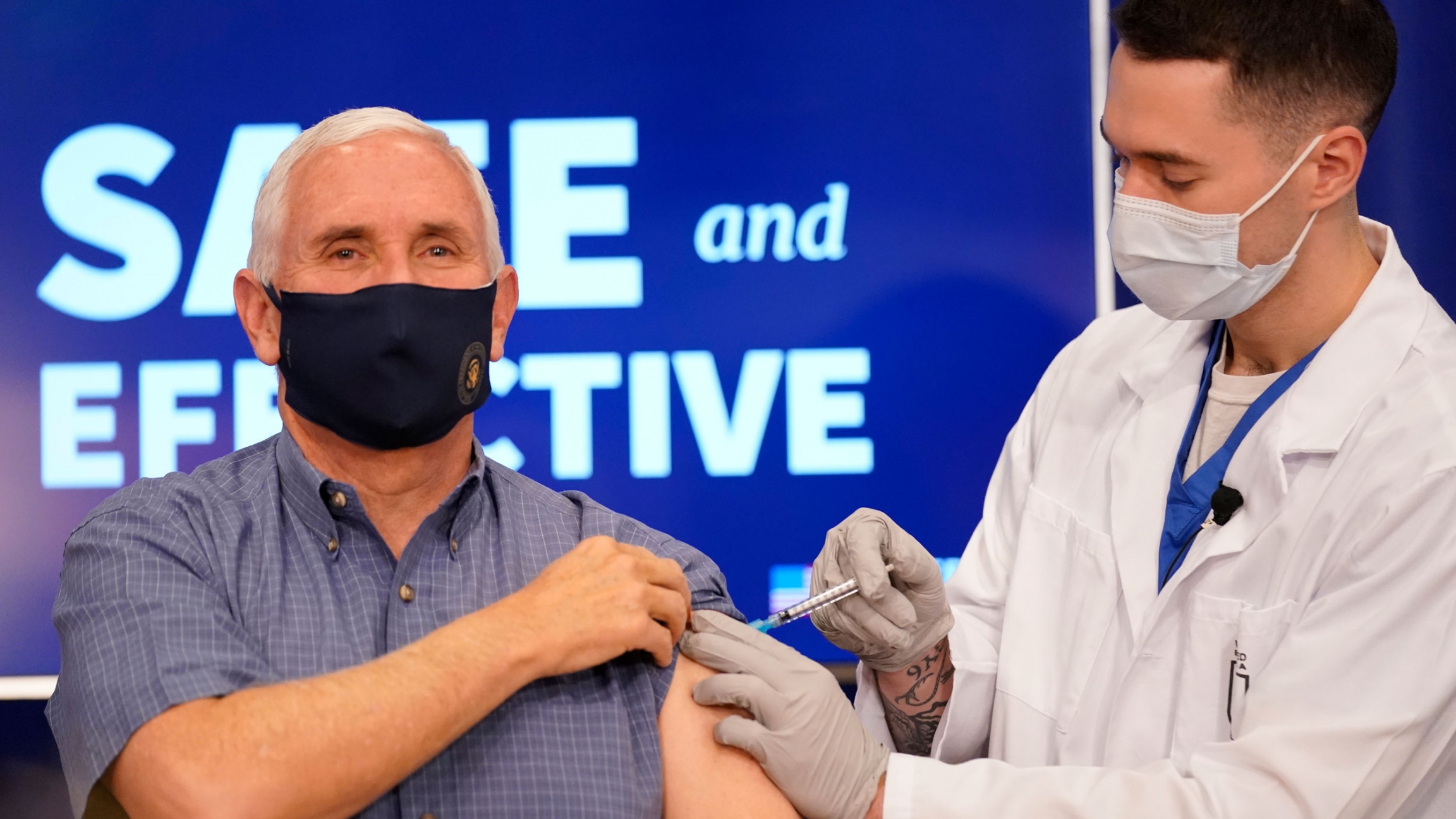 US Vice President Mike Pence receives a Pfizer-BioNTech COVID-19 vaccine shot at the Eisenhower Executive Office Building on the White House complex, Dec. 18, 2020. US Vice President Mike Pence is shown holding his sleeve up while a doctor injects the Pfizer-BioNTech COVID-19 vaccine shot in his shoulder.