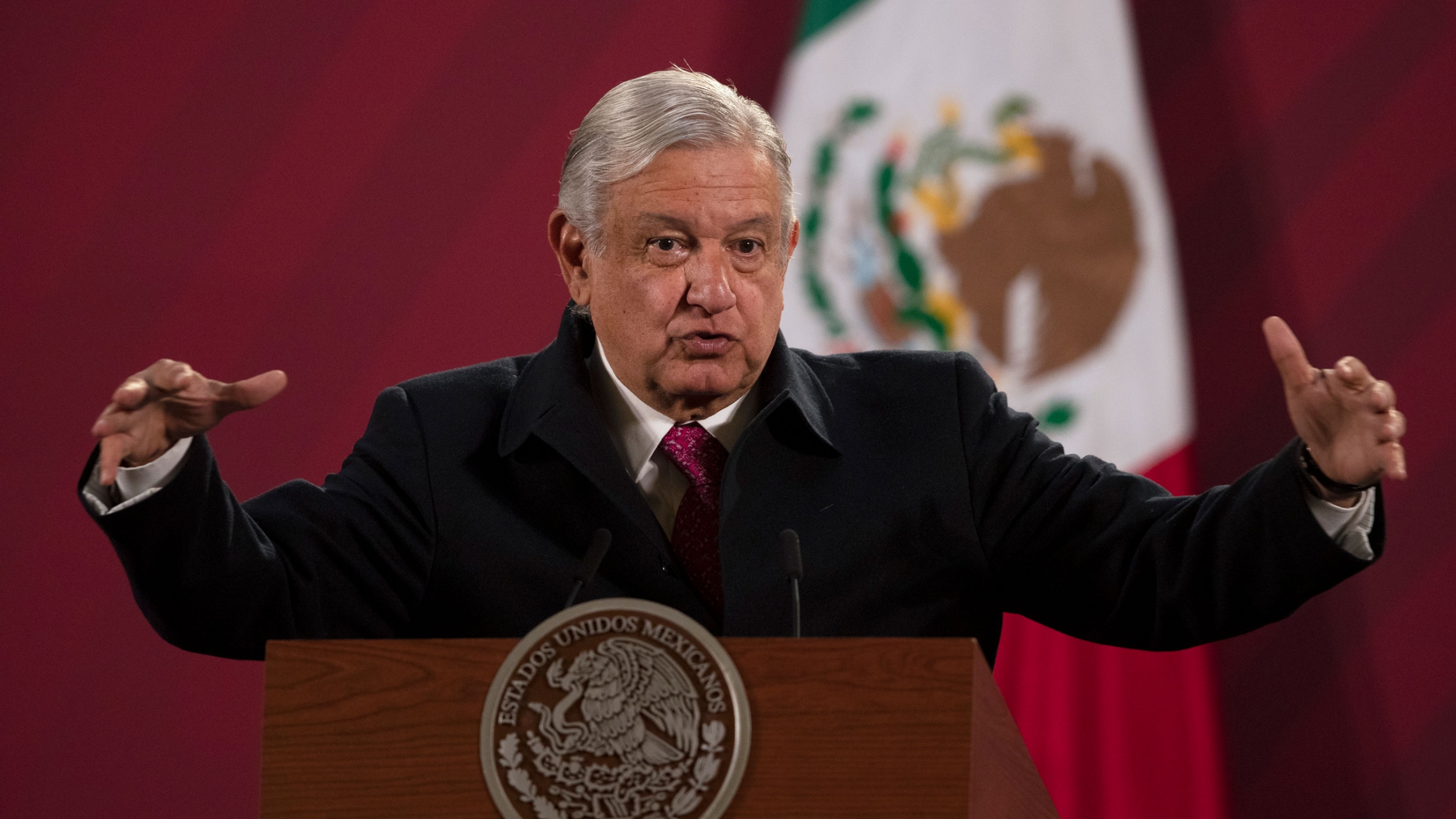 Mexican President Andrés Manuel López Obrador is shown at a news conference at the presidential palace in Mexico City, Dec. 18, 2020. Mexican President Andrés Manuel López Obrador is shown speaking while standing behind a podium with his arms outstretched.