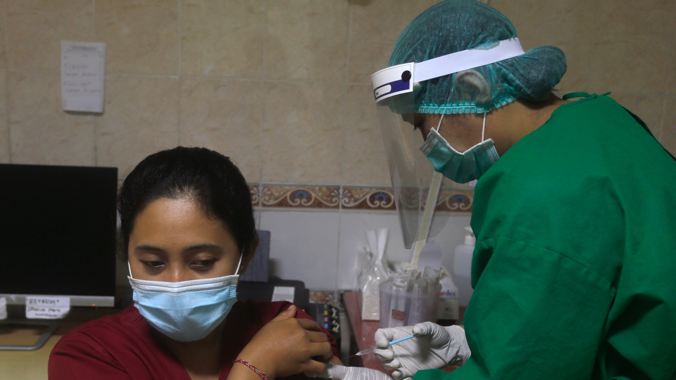 A health worker gives an injection to a mock patient during a coronavirus vaccine drill in Bali, Indonesia on Monday, Jan. 11, 2021. Indonesia's highest Islamic body has gave its religious approval to China's Sinovac vaccine, paving the way for its distri A health worker gives an injection to a mock patient during a coronavirus vaccine drill in Bali, Indonesia.