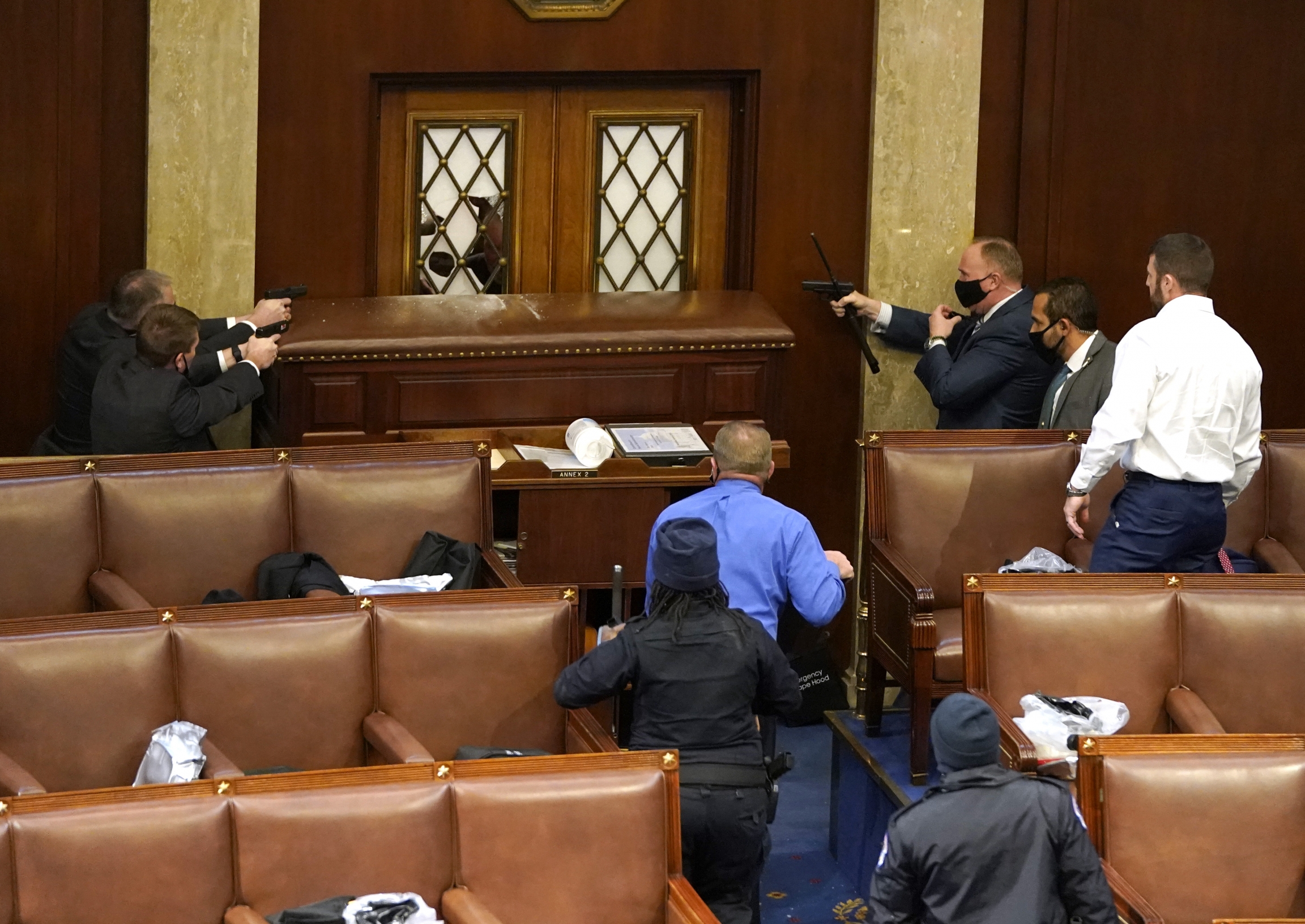 US Capitol police officers point their guns at a door that was vandalized in the House Chamber during a joint session of Congress on Jan. 06, 2021, in Washington, DC. US Capitol police officers point their guns at a door that was vandalized in the House Chamber during a joint session of Congress on Jan. 06, 2021, in Washington, DC.