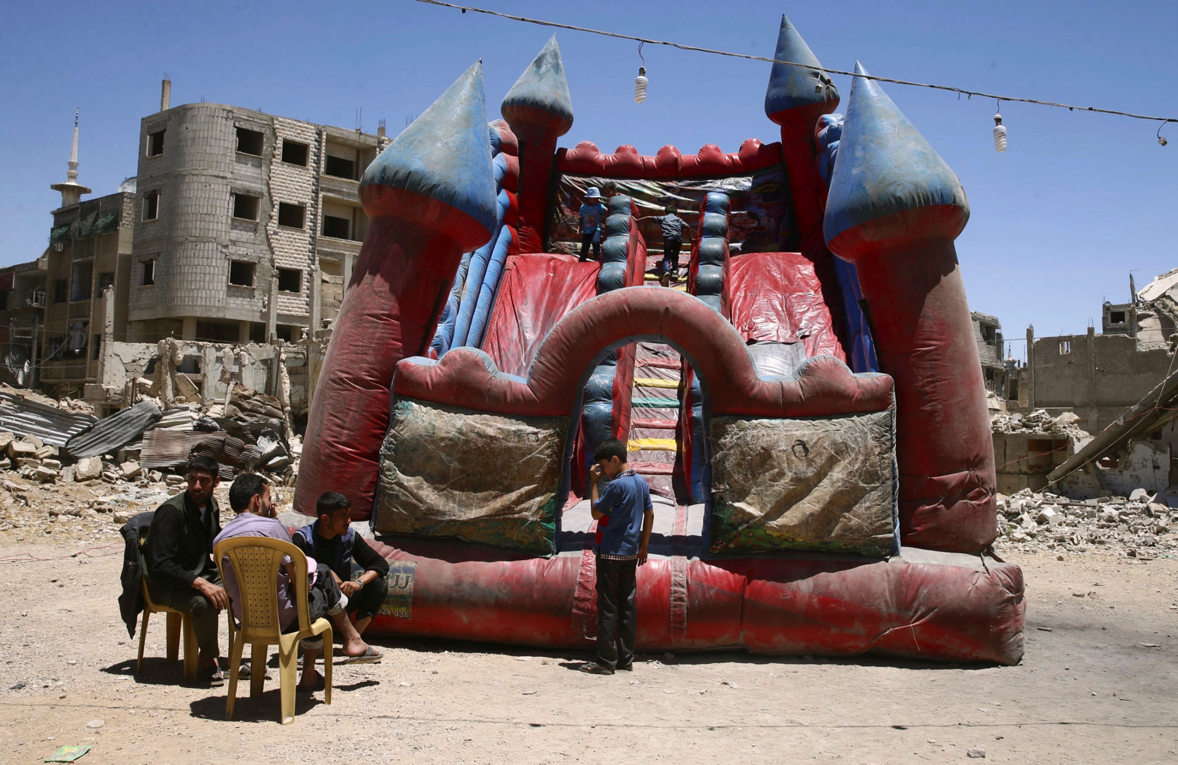 Children play inside an inflatable castle during Eid al-Fitr celebration in the Douma neighborhood of Damascus, Syria, June 26, 2017. Children play inside an inflatable castle during Eid al-Fitr celebration in the Douma neighborhood of Damascus, Syria, June 26, 2017.