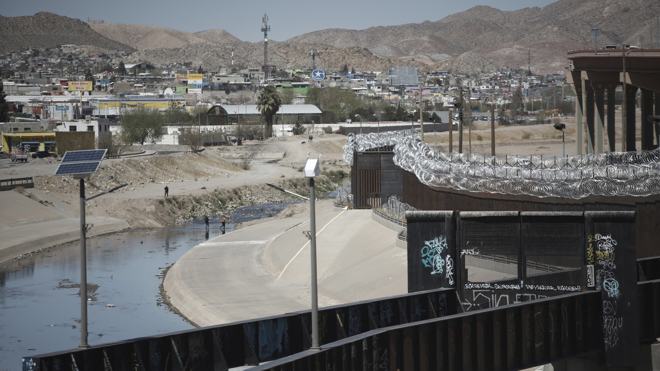 People cross the border between US and Mexico
