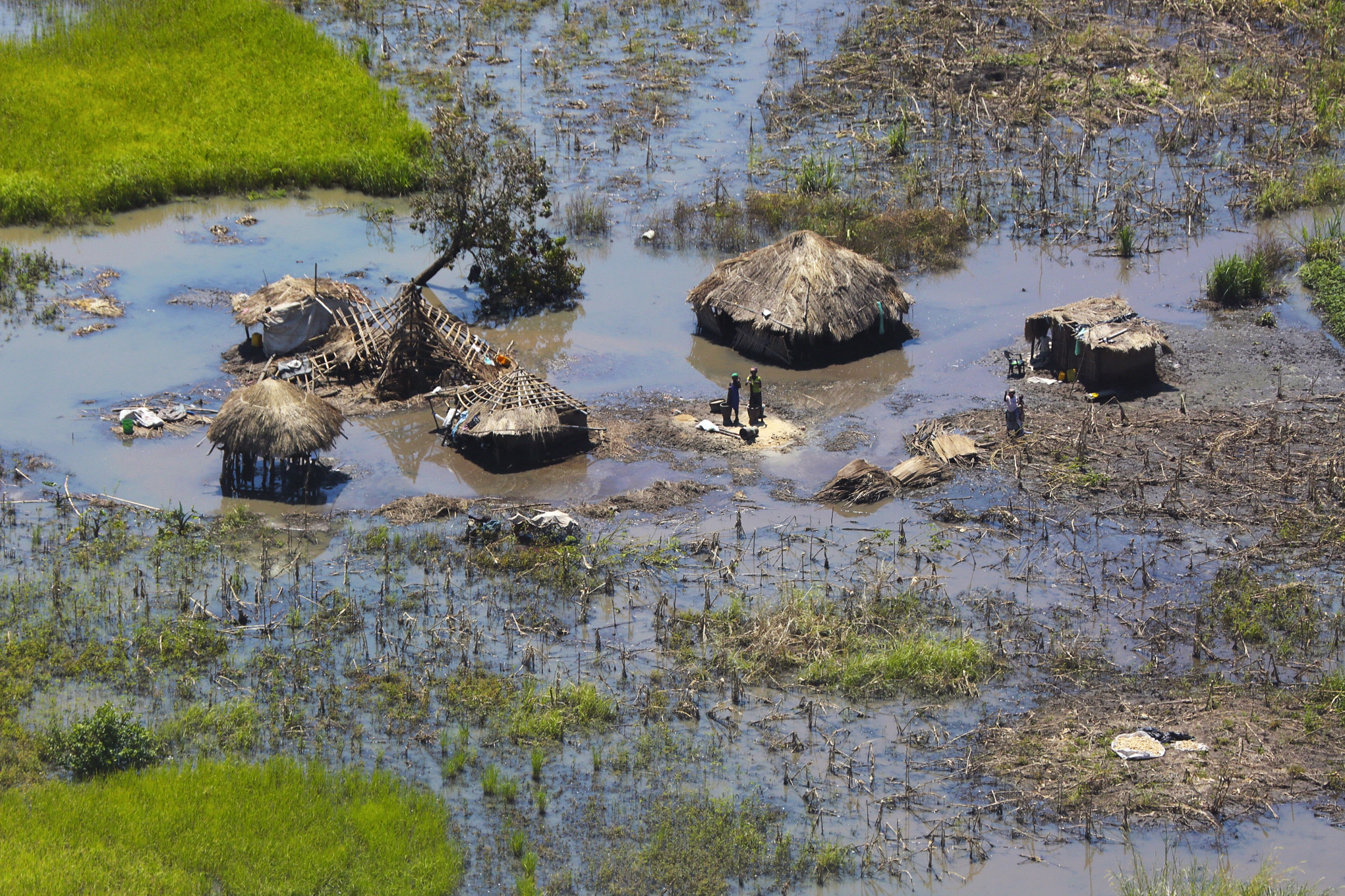 People stand outside their submerged homes near Nhamatanda, about 80 miles from Beira, in Mozambique, on March 26, 2019. People stand outside their submerged homes near Nhamatanda, about 80 miles from Beira, in Mozambique, on March 26, 2019.