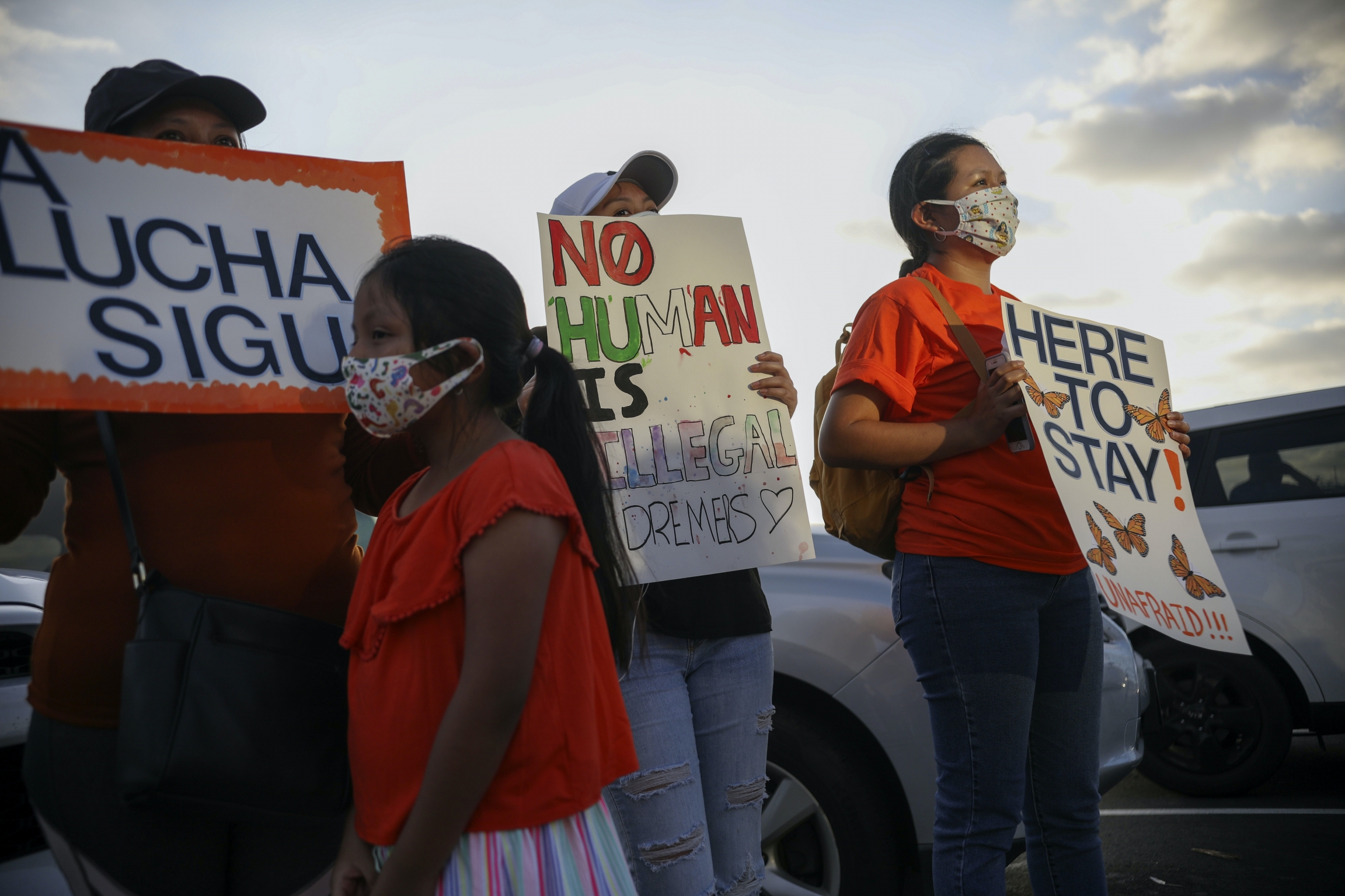 Demonstrators with signs with clouds behind them, including a child