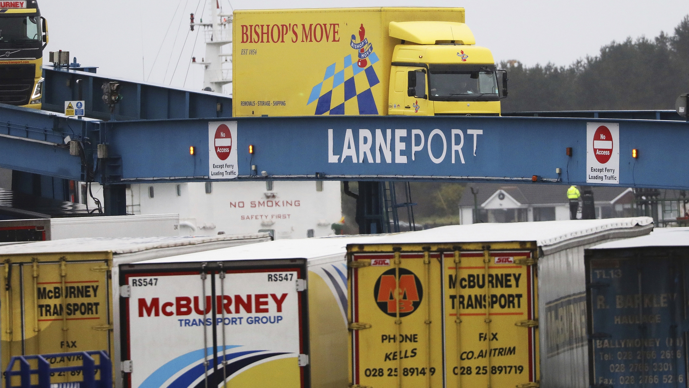 In this file photo dated Tuesday, Feb. 2, 2021, vehicles disembark from a ferry arriving from Scotland at the port of Larne, Northern Ireland. Blue, yellow, and white vehicles disembark from a ferry arriving from Scotland.