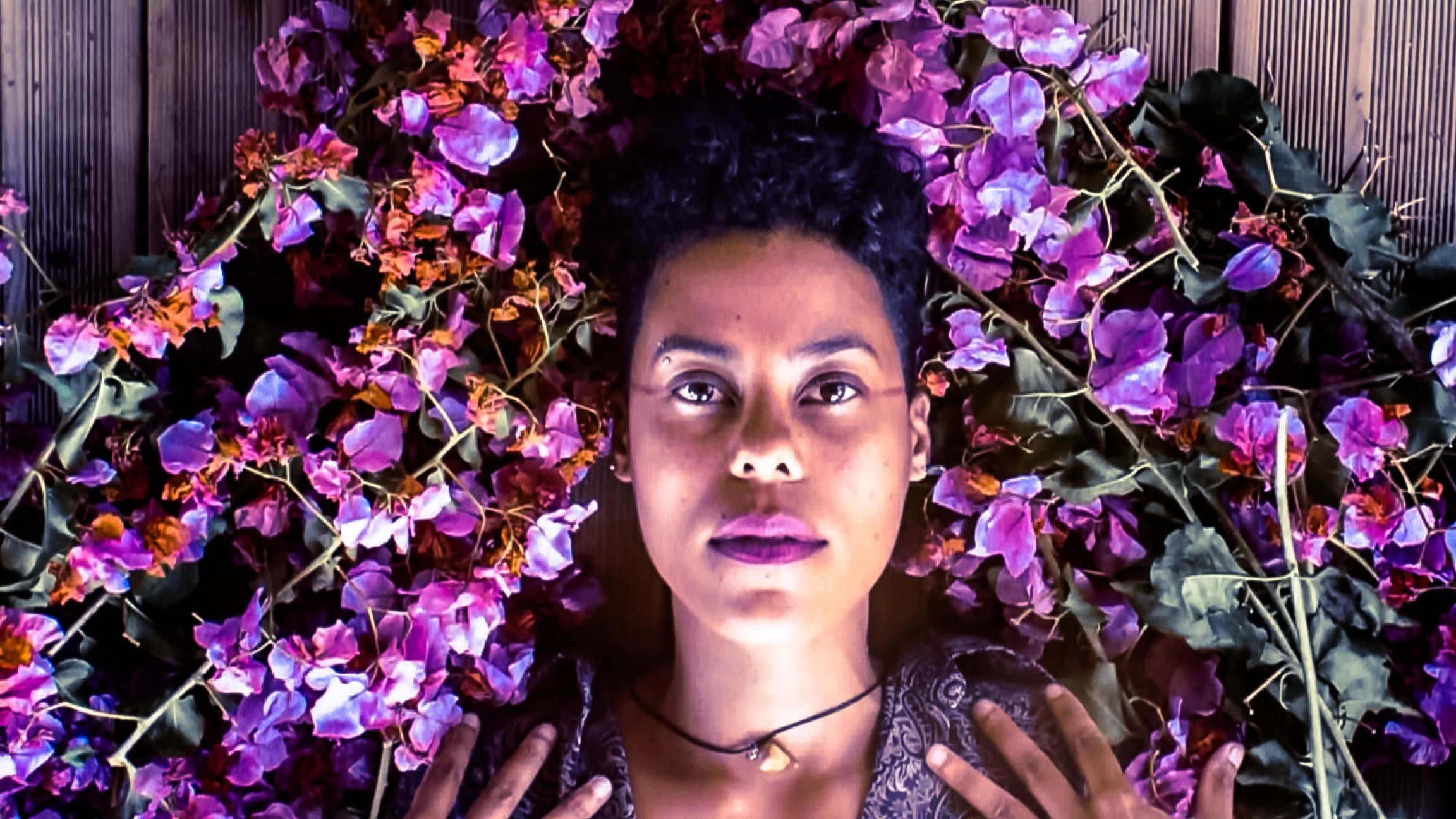 Reunion Island artist Dilo uses sounds from nature to celebrate it. Reunion Island artist Dilo surrounded by pink and magenta flowers around her head.