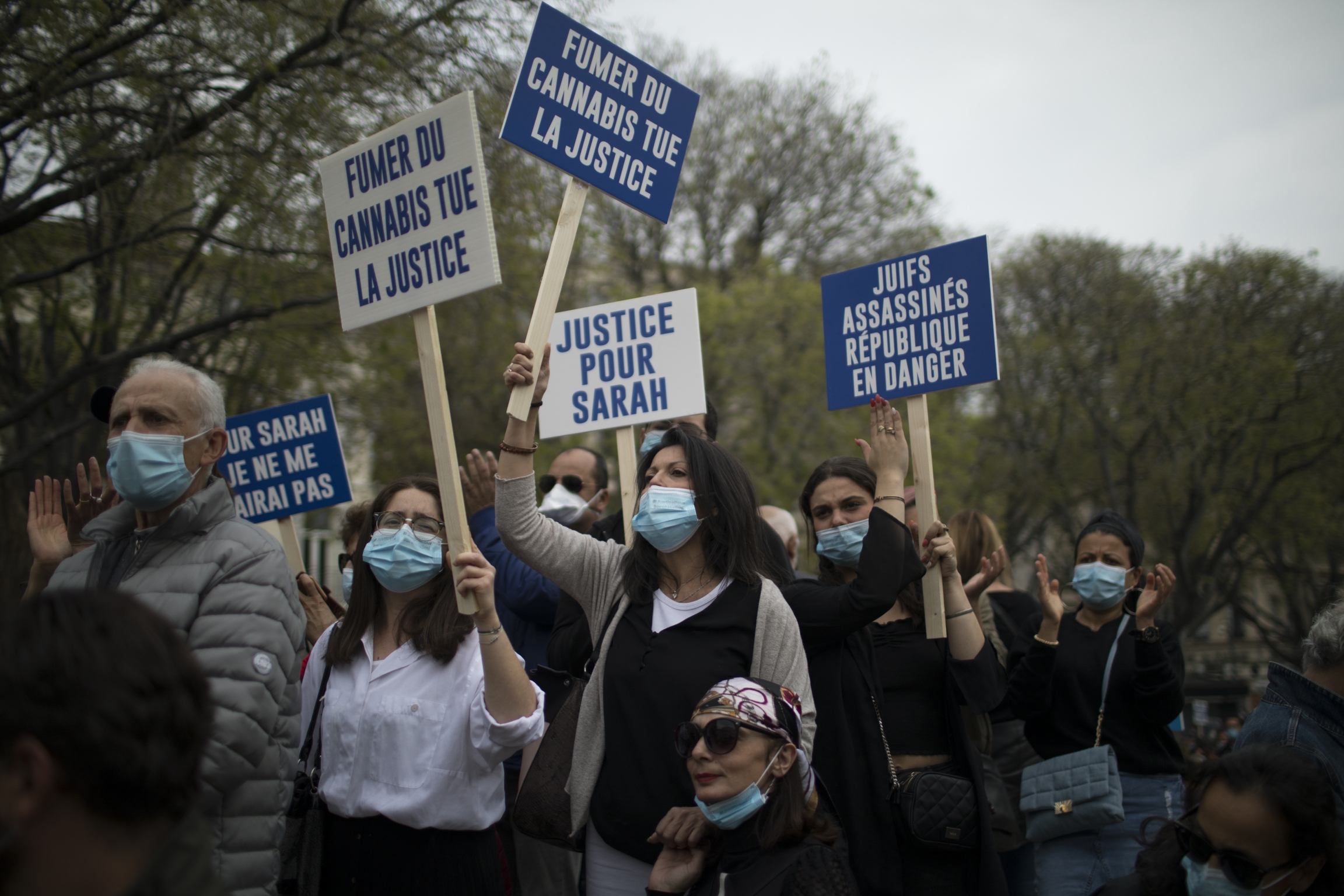 Protesters shout during a demonstration demanding justice for Jewish murder victim Sarah Halimi in Marseille, southern France, Sunday, April 25, 2021. Protesters hold blue and white signs in French that read "Justice for Sarah."