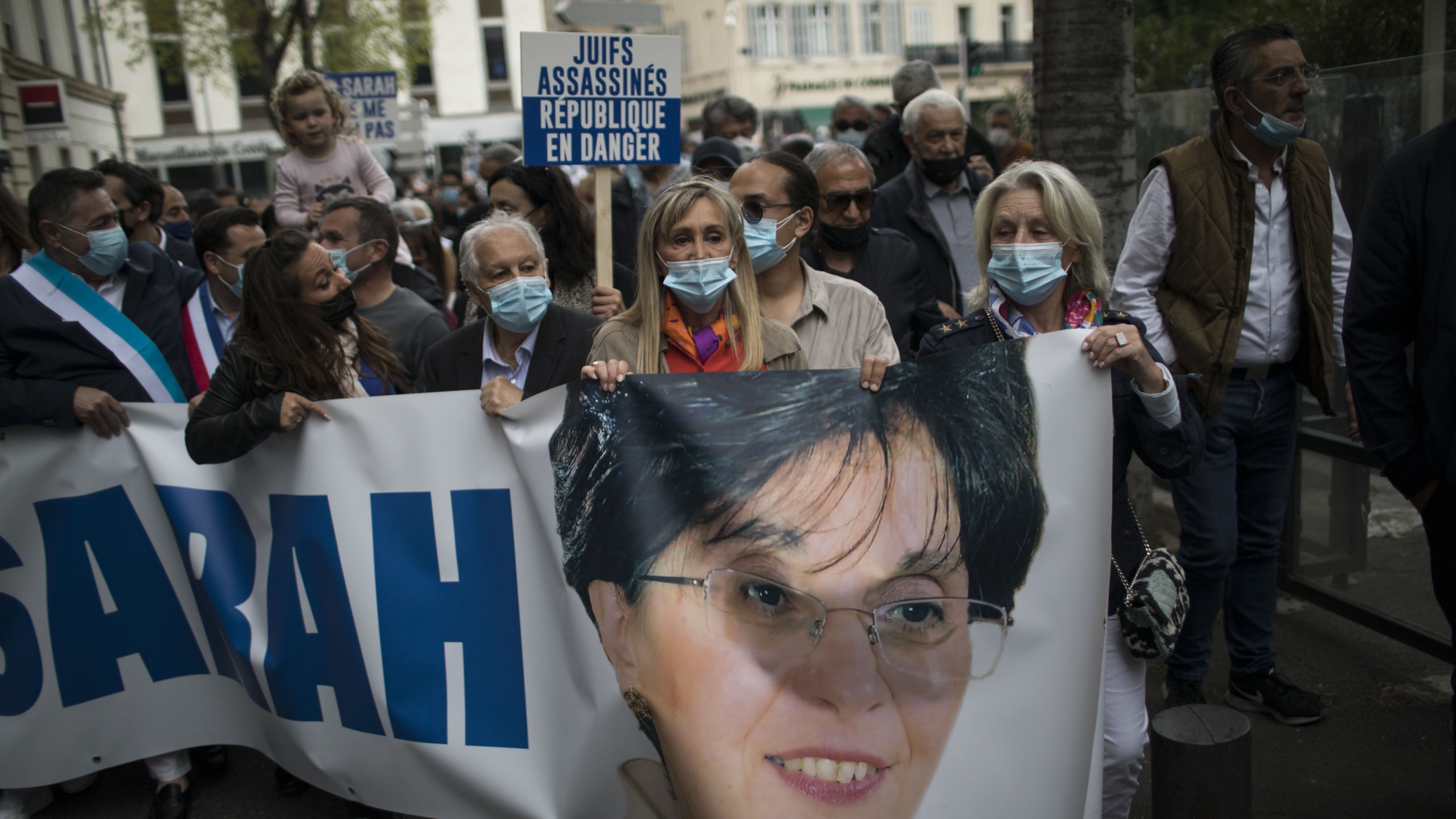 Protesters march with a banner of killed Jewish woman Sarah Halimi, during a demonstration in Marseille, southern France, April 25, 2021. Protesters carry a banner with Sarah Halimi's face and name printed on it in a protest over a court's decision not to try her killer.