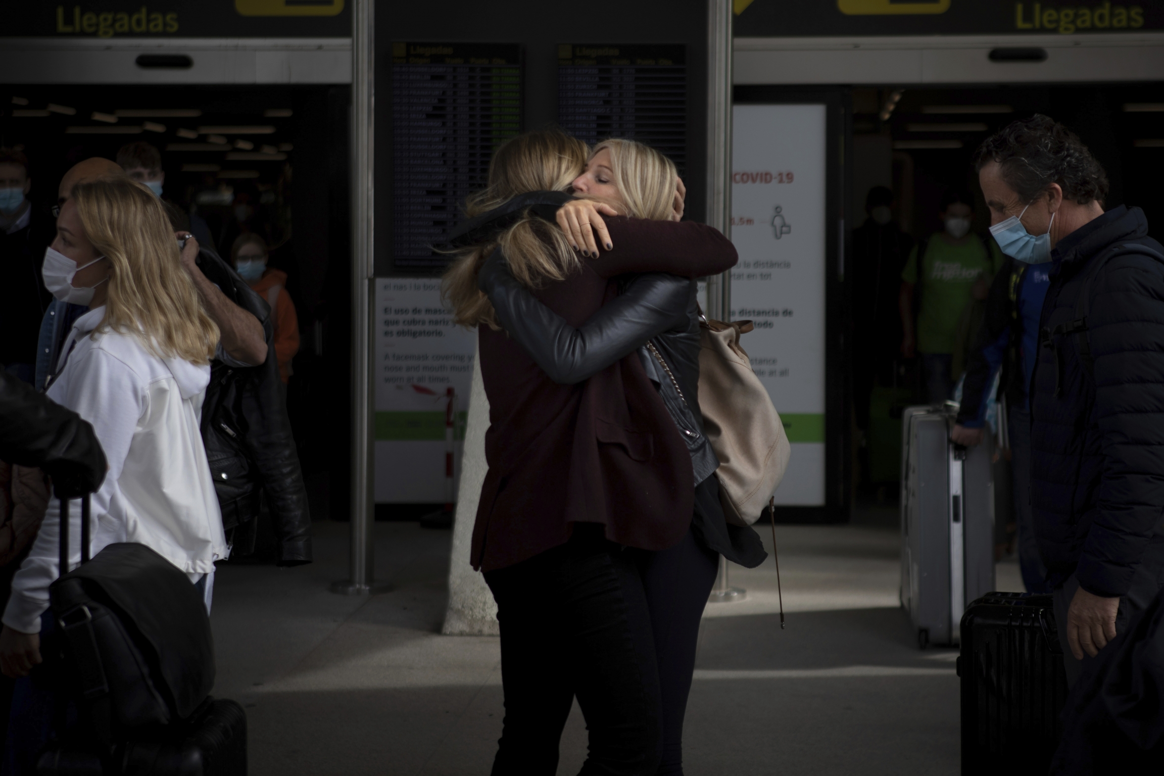 Two women meet at Palma de Mallorca Airport on the Spanish Balearic Island of Mallorca, Spain, Saturday, March 27, 2021. Two women in black clothing embrace in an airport