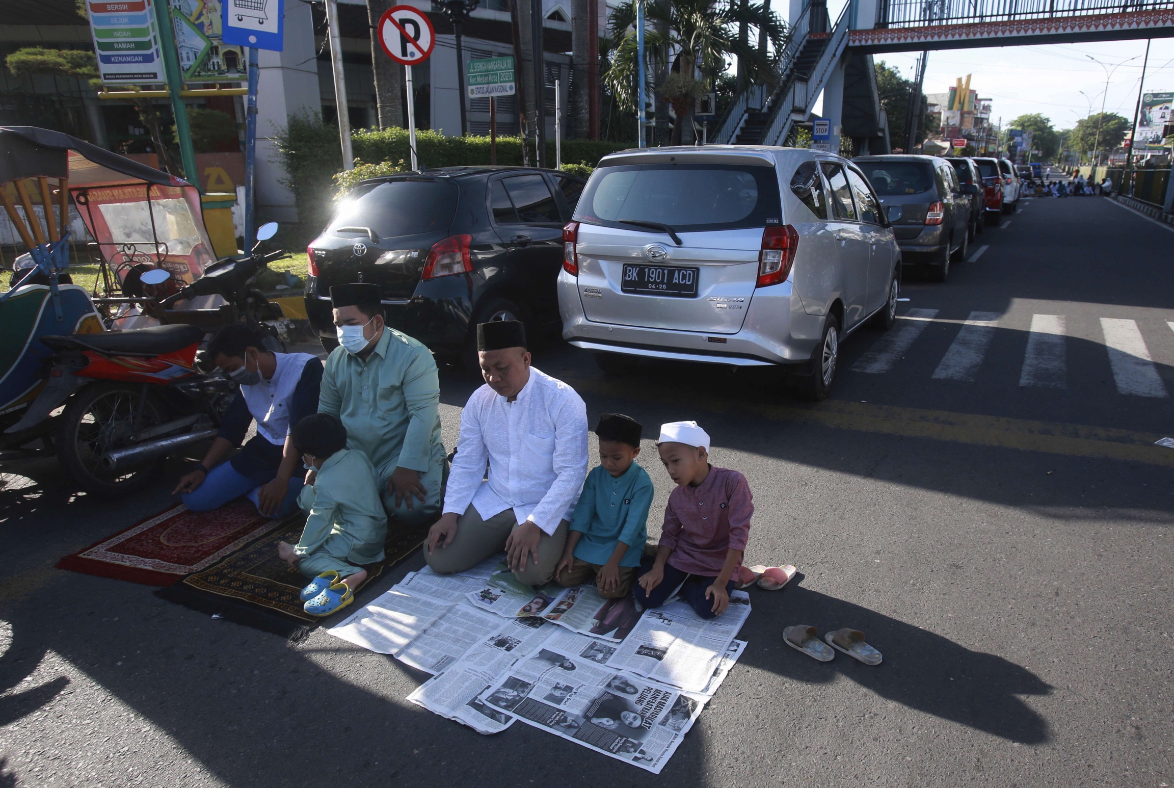 Muslim men pray on a street outside a crowded Al Mashun Great Mosque during an Eid al-Fitr prayer in Medan, North Sumatra, Indonesia, on Thursday, May 13, 2021. Muslim men pray on a street outside a crowded Al Mashun Great Mosque during an Eid al-Fitr prayer in Medan, North Sumatra, Indonesia, on Thursday, May 13, 2021.