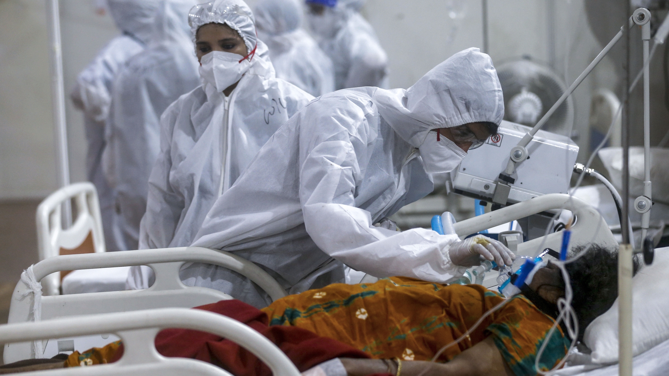 In this May 6, 2021, file photo, health worker tries to adjust the oxygen mask of a patient at the BKC jumbo field hospital, one of the largest COVID-19 facilities in Mumbai, India. A health worker tries to adjust the oxygen mask of a patient at the BKC jumbo field hospital.