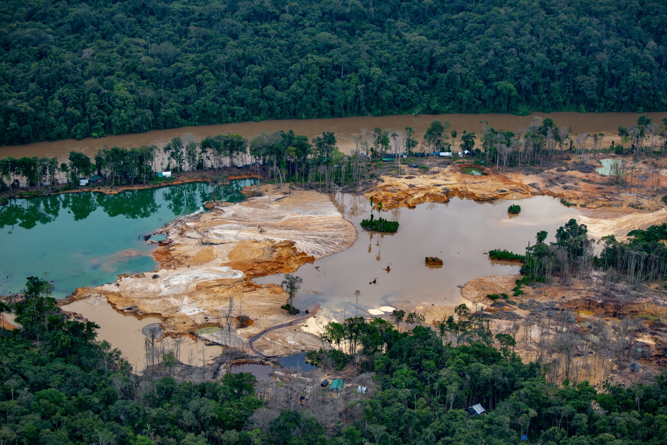 Environmental devastation caused by illegal mining operations in Yanomami land. Environmental devastation caused by illegal mining operations in Yanomami land.