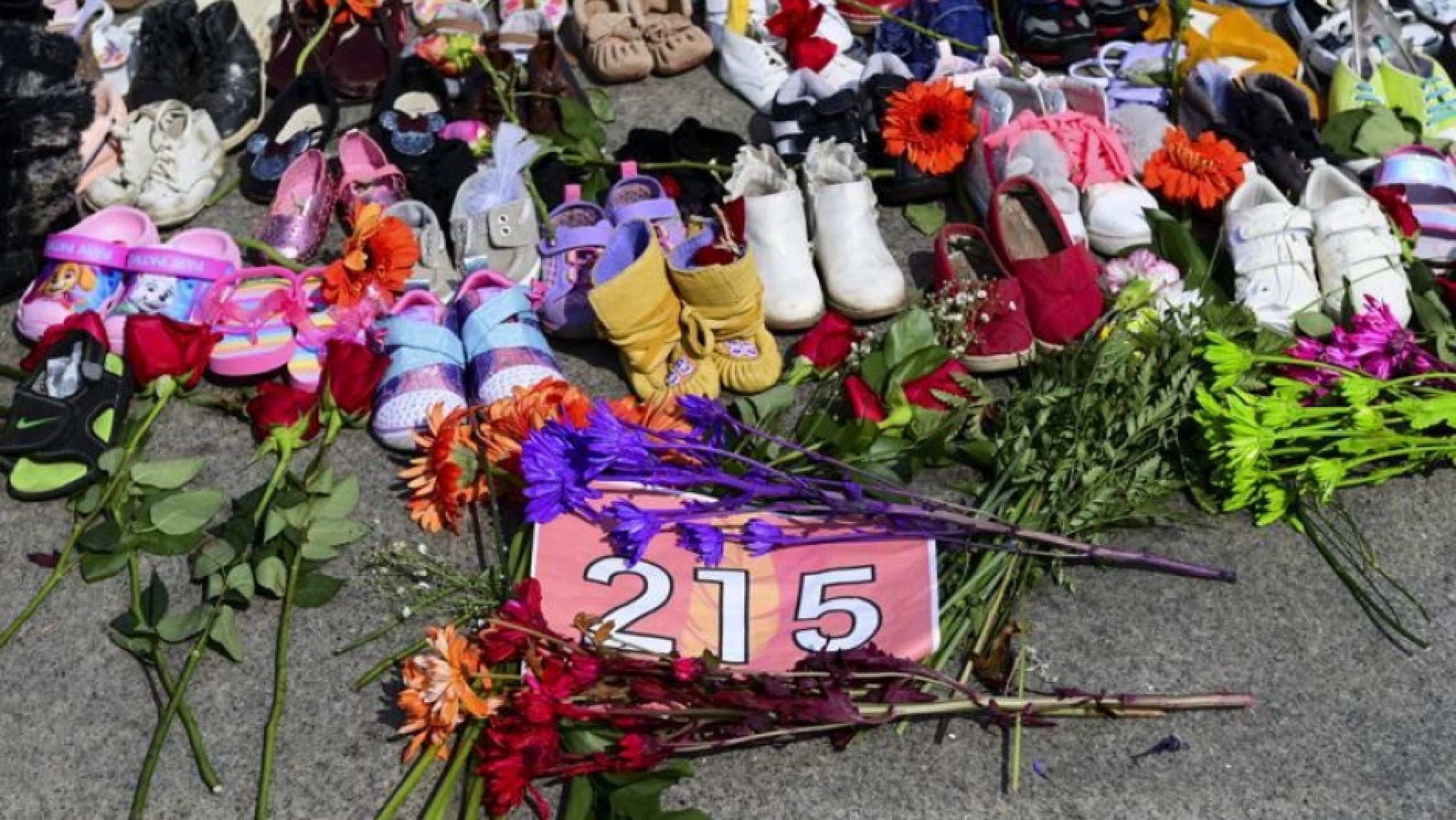 Flowers, children's shoes and other items rest at a memorial at the Eternal Flame on Parliament Hill in Ottawa Flowers, children's shoes and other items rest at a memorial at the Eternal Flame on Parliament Hill in Ottawa