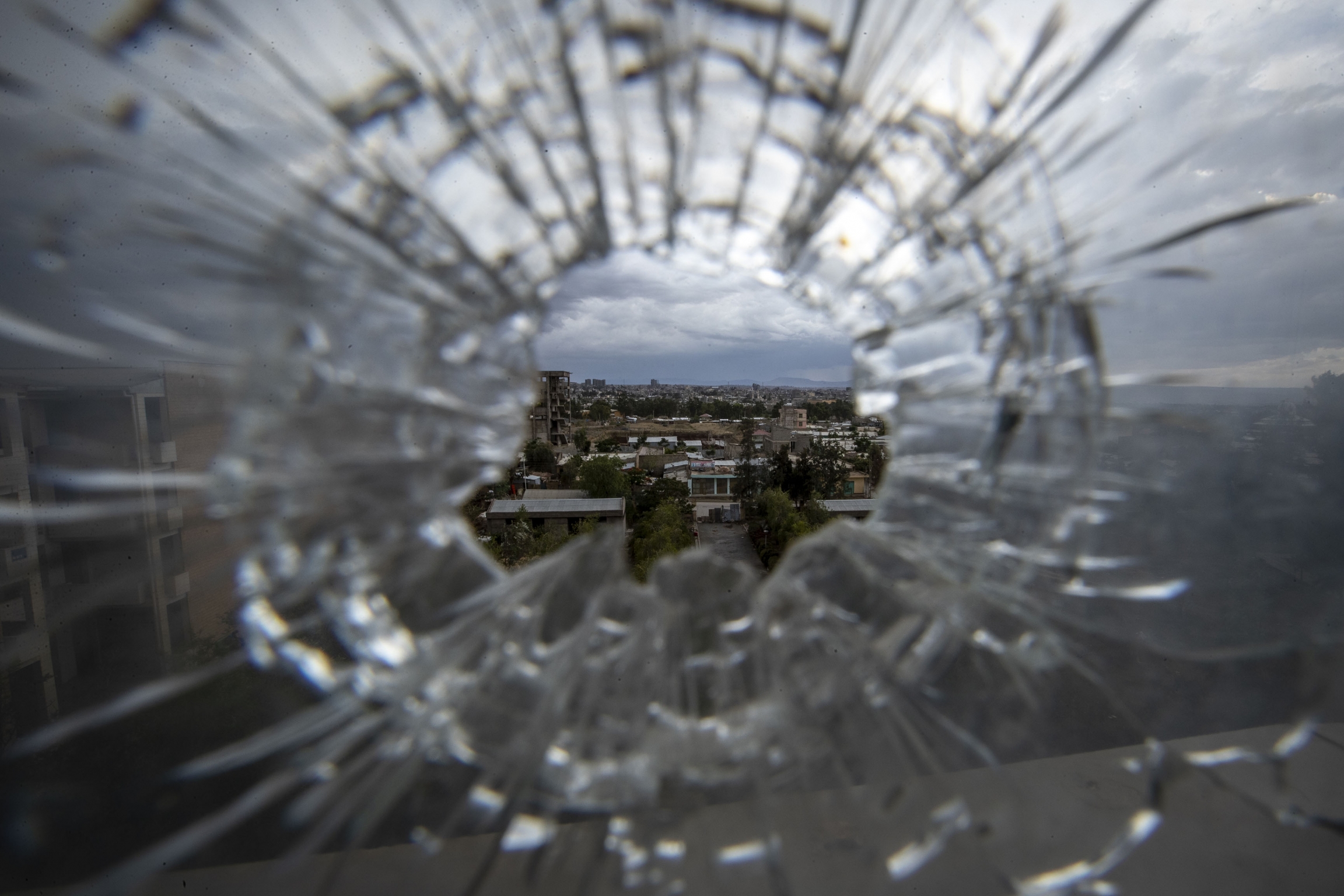 The city of Mekele is seen through a bullet hole in a stairway window of the Ayder Referral Hospital, in the Tigray region of northern Ethiopia, on Thursday, May 6, 2021. Glass shattered from bullet.