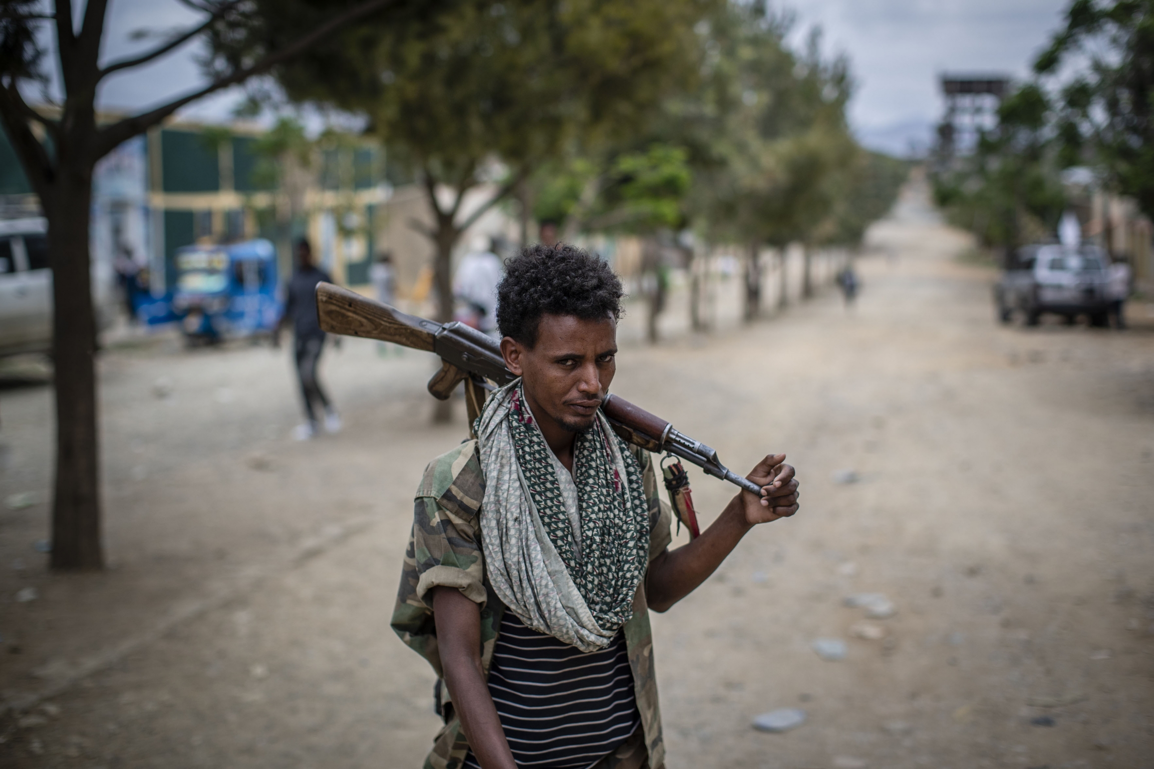 A fighter holds a gun in the street.