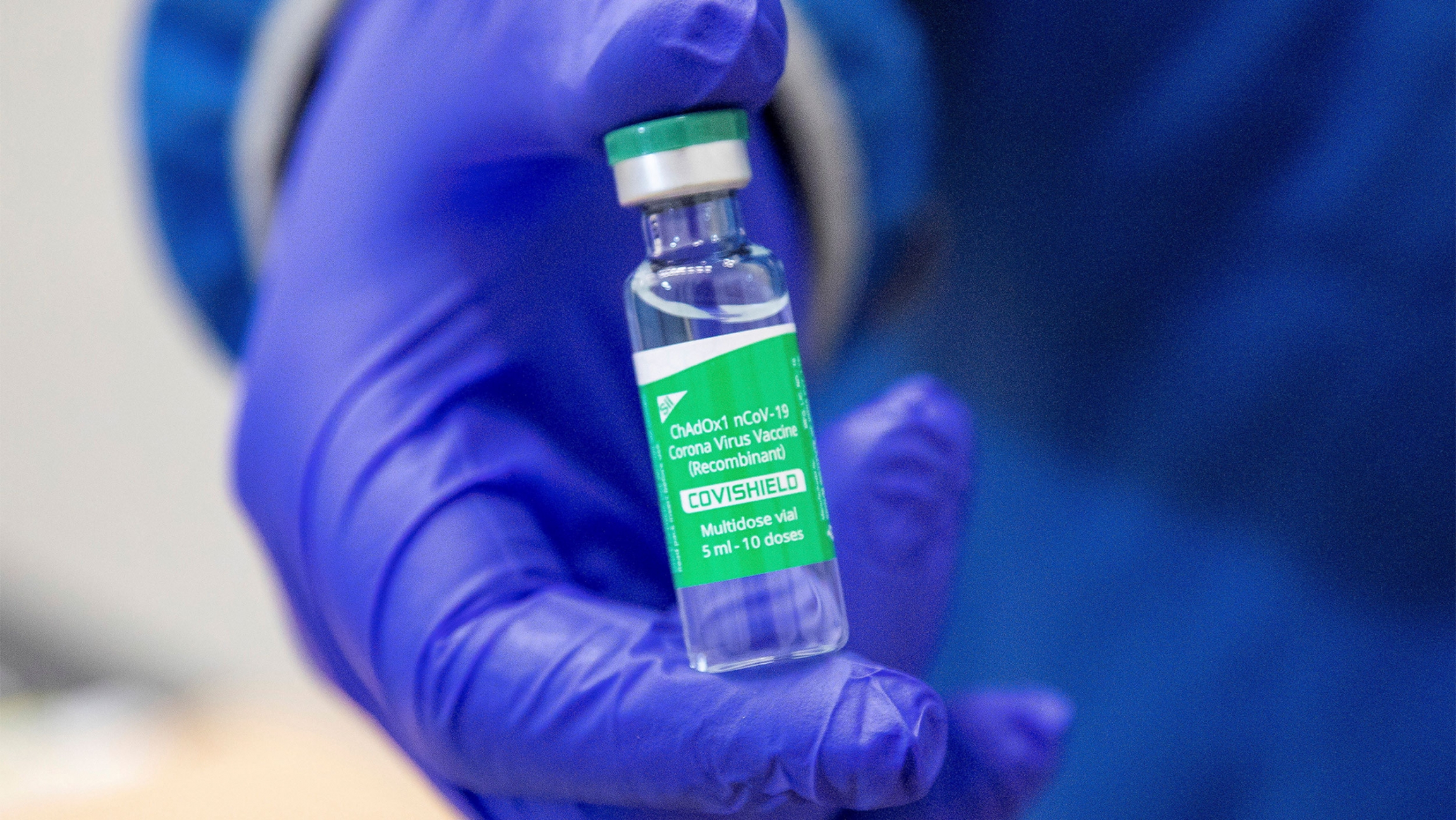 A vial of the AstraZeneca COVID-19 vaccine dose in Milton, Ontario A person wearing blue gloves presents a vial of an AstraZeneca COVID-19 vaccine dose