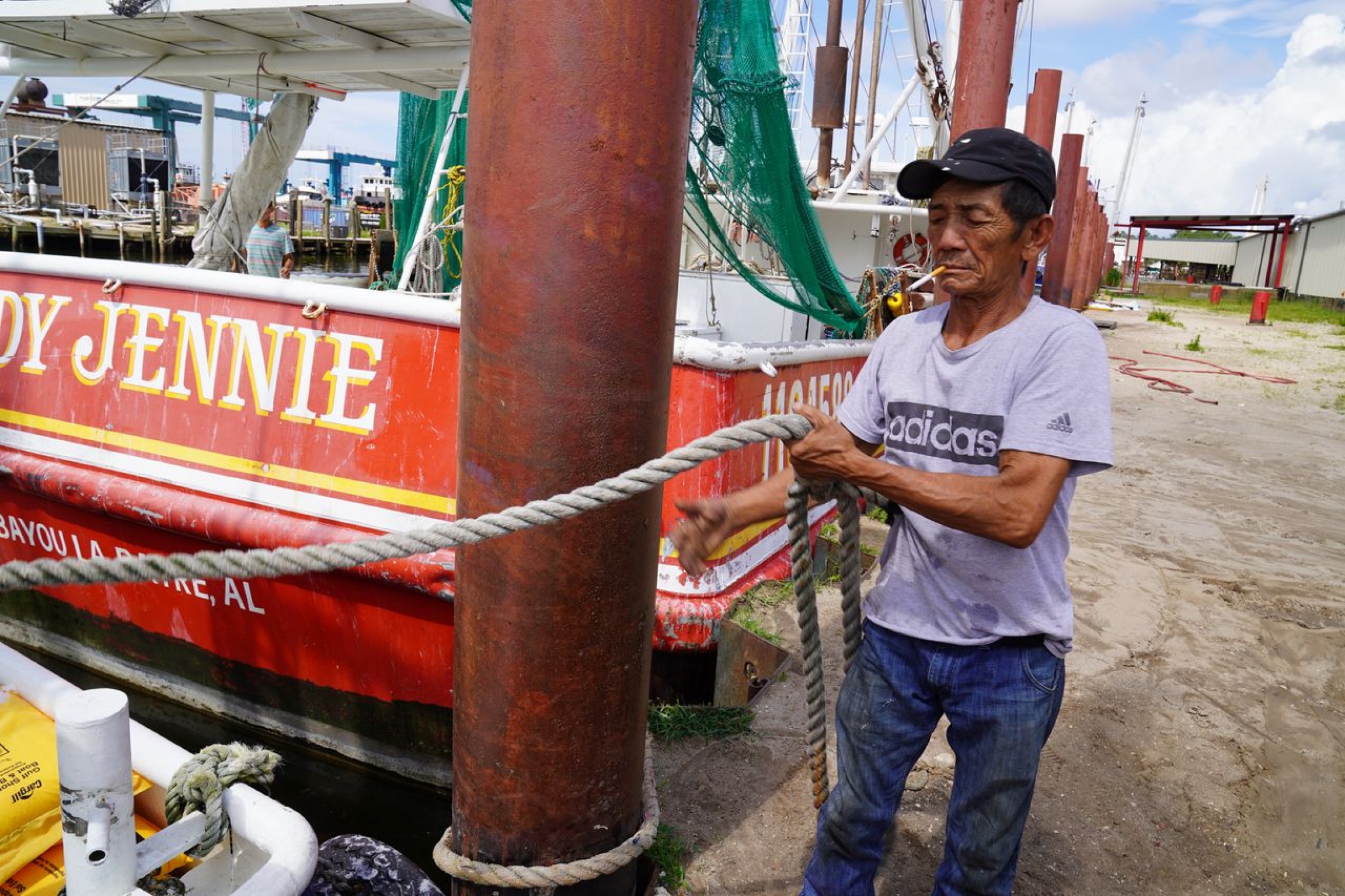 Shrimp boat Captain Truc Le A man in a white T-shirt pulls a boat by a rope