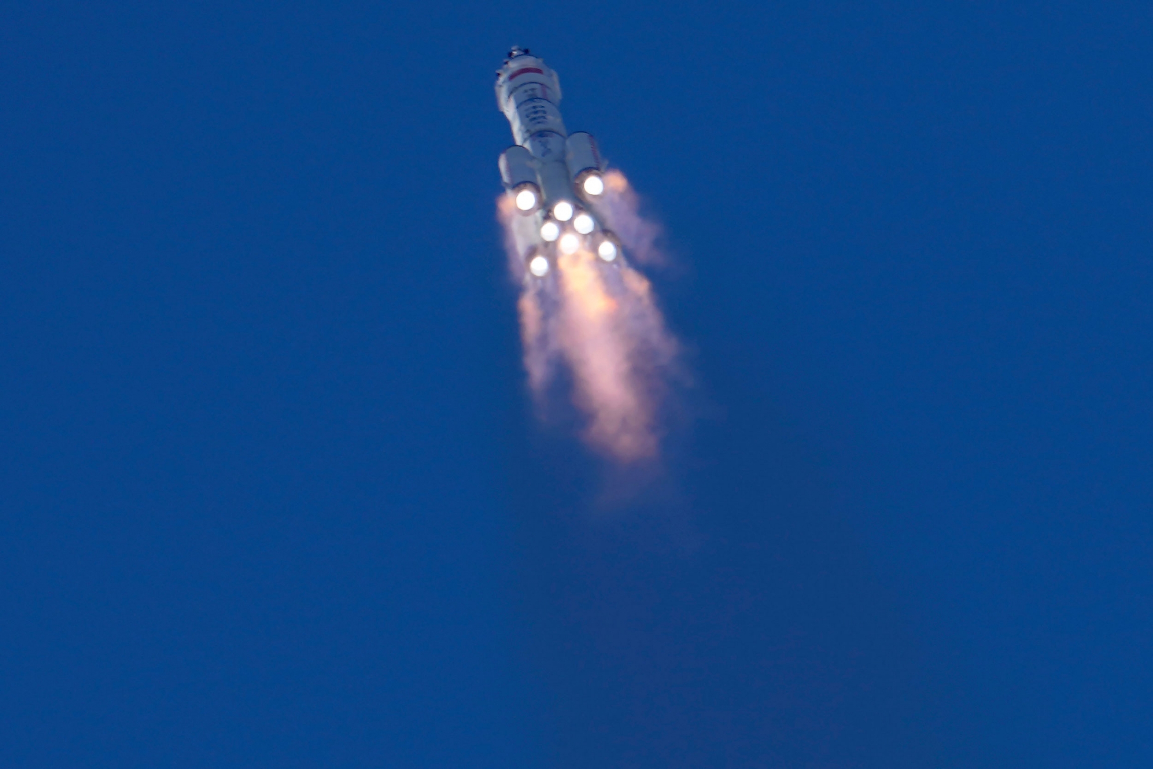 China has launched the first three-man crew to its new space station in the program's first crewed mission. The firey bottom of eight rockets are shown from below lifting the Chinese spaceship into the sky.