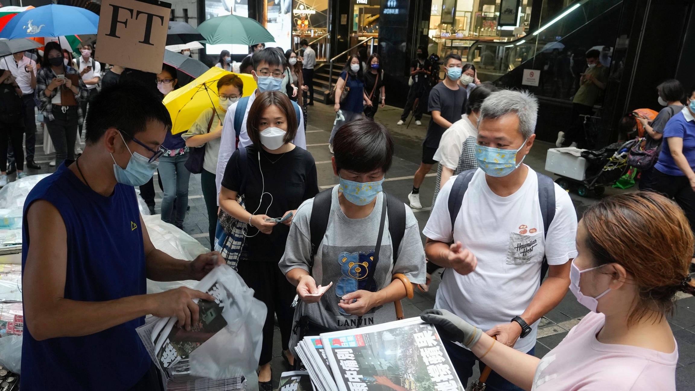 People queue up for last issue of Apple Daily at a newspaper booth at a downtown street in Hong Kong, June 24, 2021. A line of people are shown waiting to purchase the last print edition of the Hong Kong newspaper, Apple Daily.