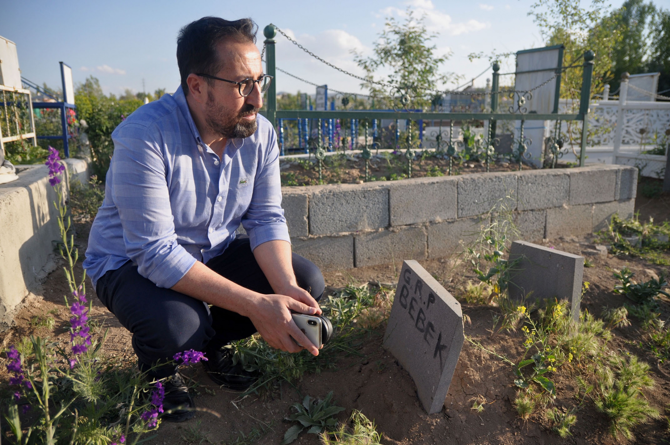 Mahmut Kaçan, an attorney with the Van Bar Association, sits near a grave for an infant who died on the journey to Turkey. Mahmut Kaçan, an attorney with the Van Bar Association, sits near a grave for an infant who died on the journey to Turkey.